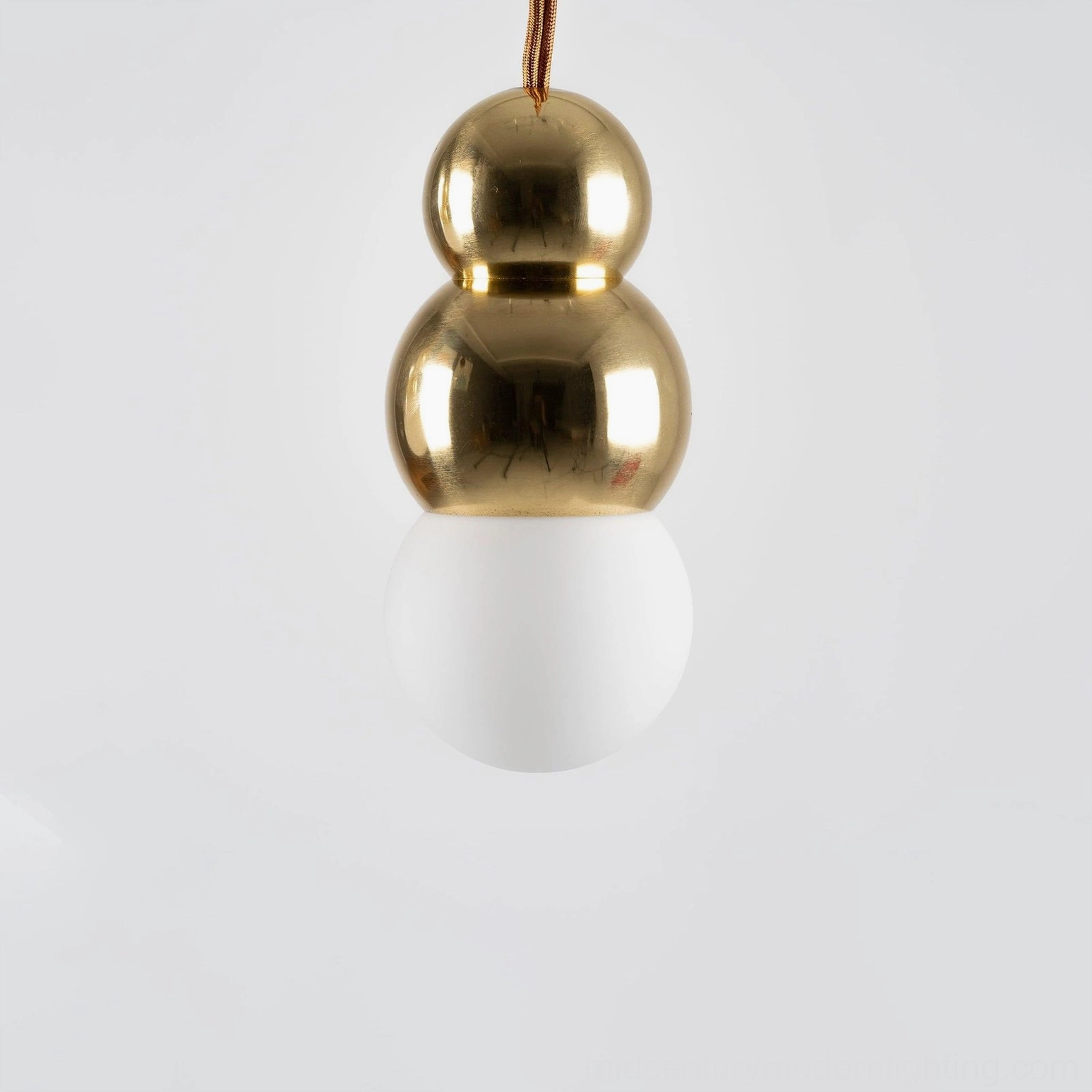 Large-scale ball pendant light with oversized stacked gold spheres and frosted white bulb, contemporary design