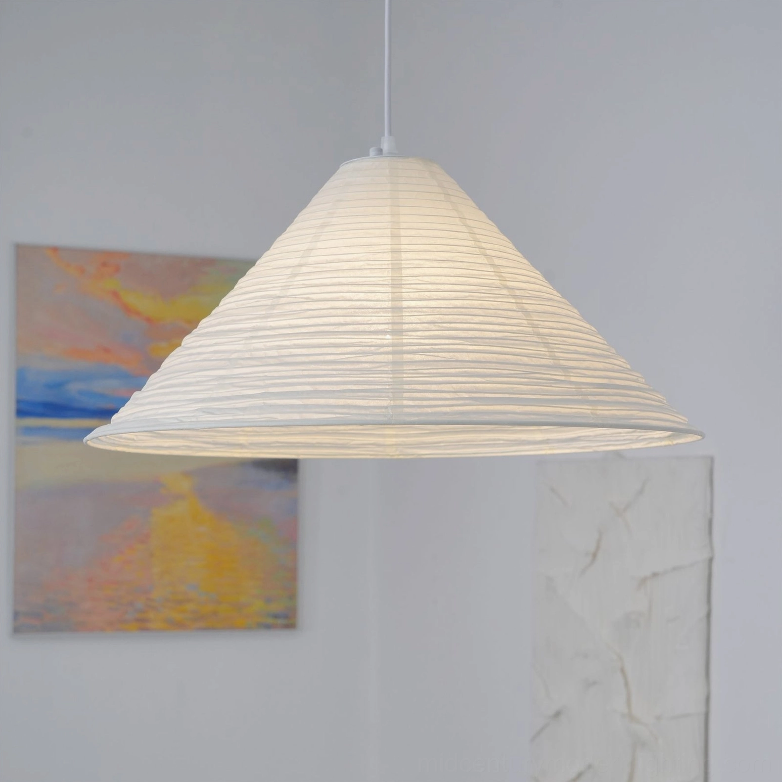 Large Cone Washi Pendant Light with horizontal ribbed texture hanging in minimalist room with wall artwork