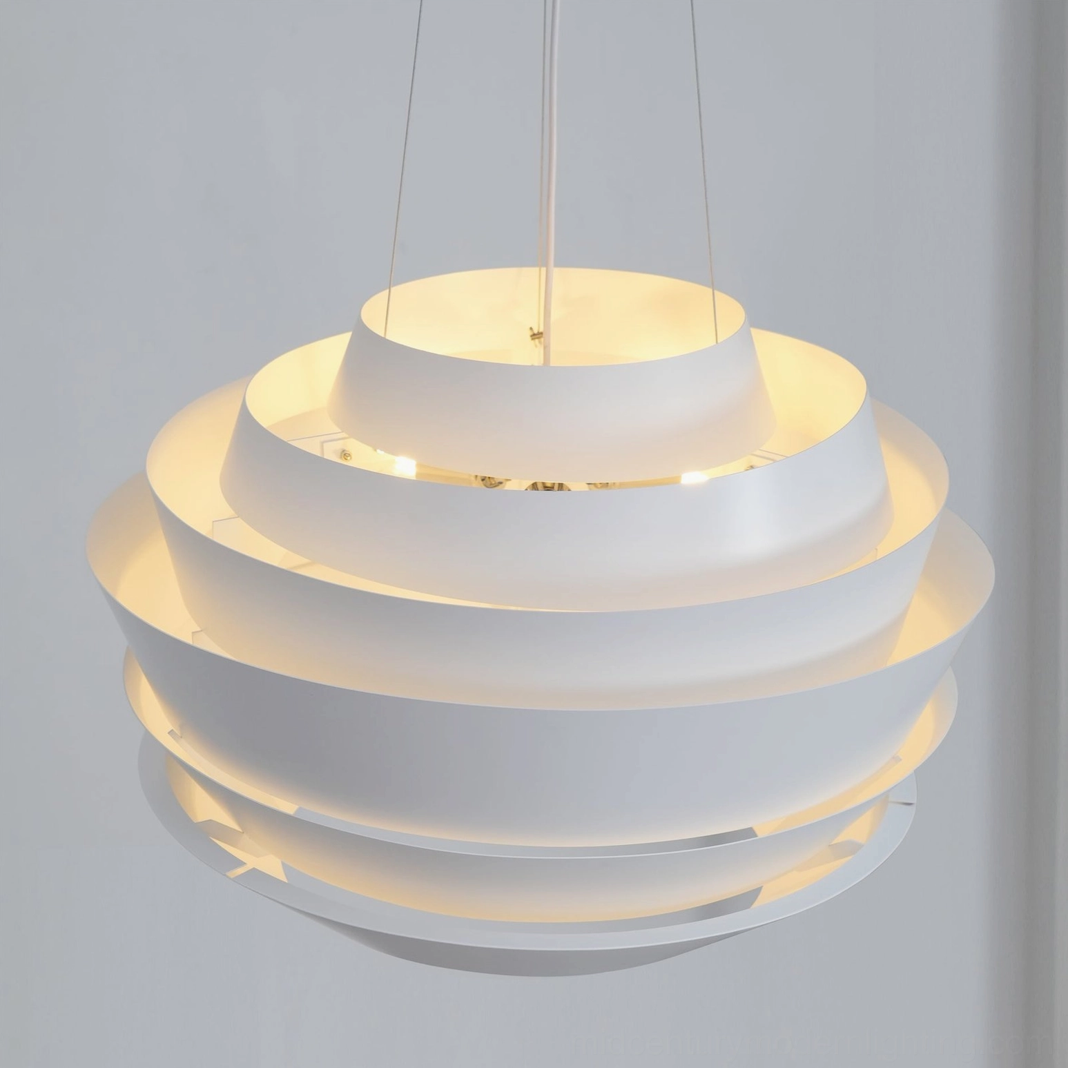 Illuminated tiered pendant light front low angle view exposed warm LED bulbs