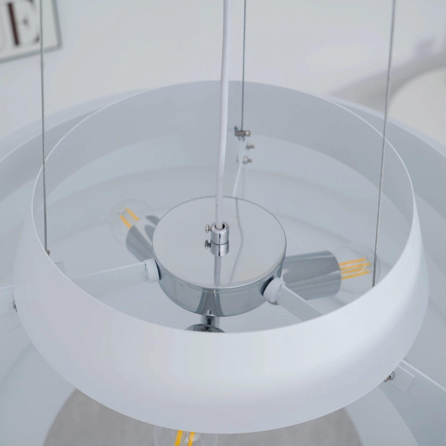 Close-up internal fixture pendant lamp chrome metal hardware and LED bulbs mechanism