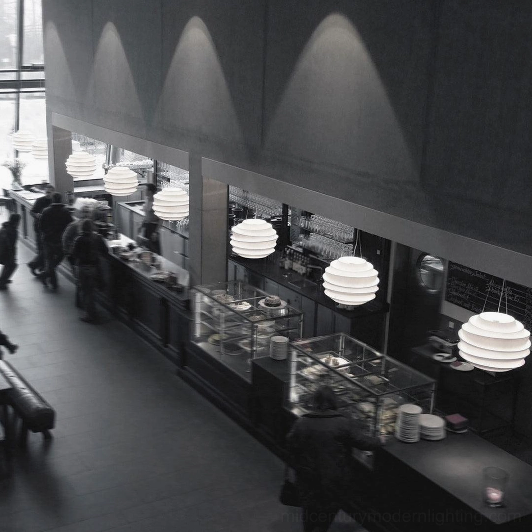 Pendant lamp warm light emission between tiers ambient glow matte white surface