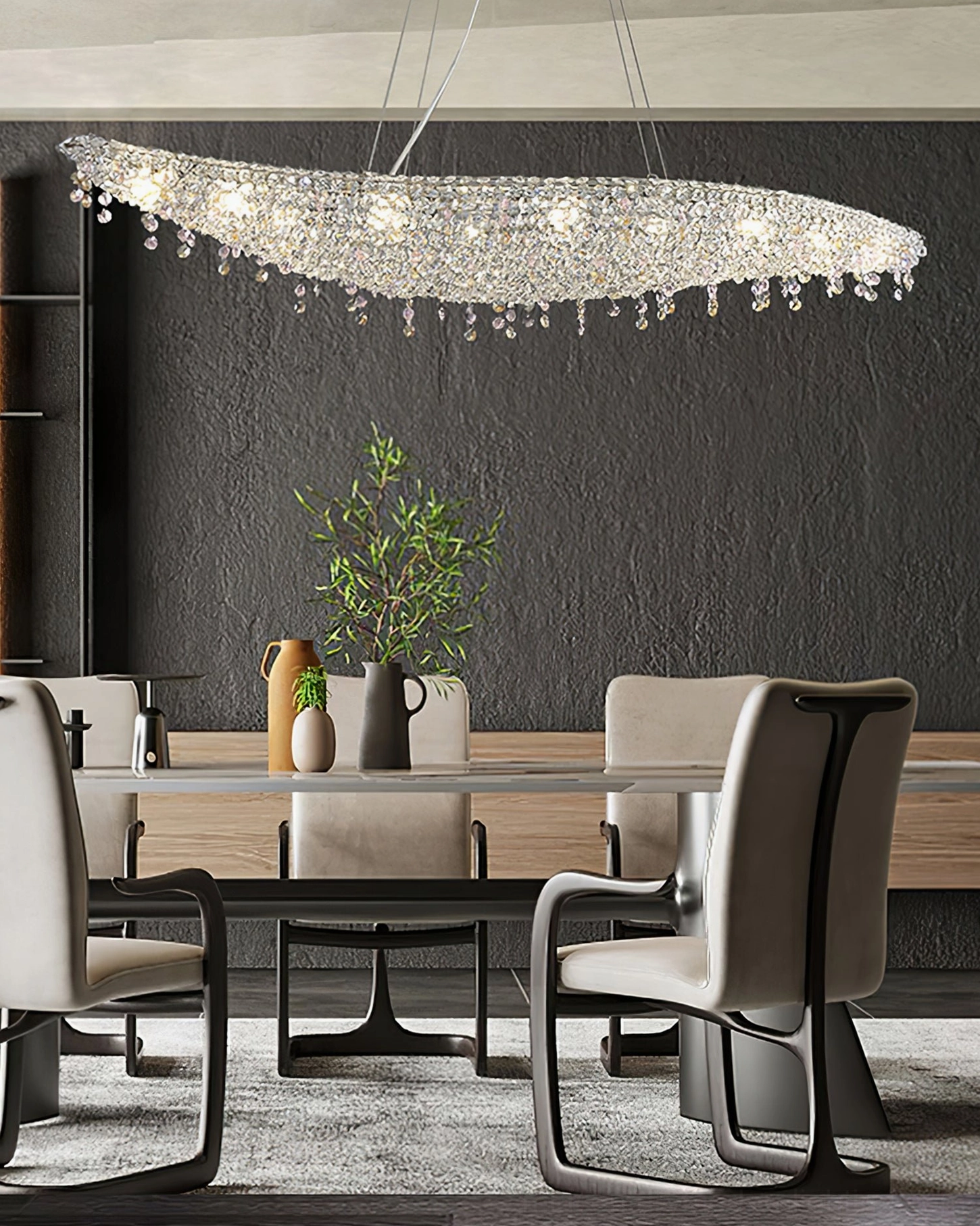 Leaves crystal chandelier mounted above long dining table in contemporary dining room with dark accent wall