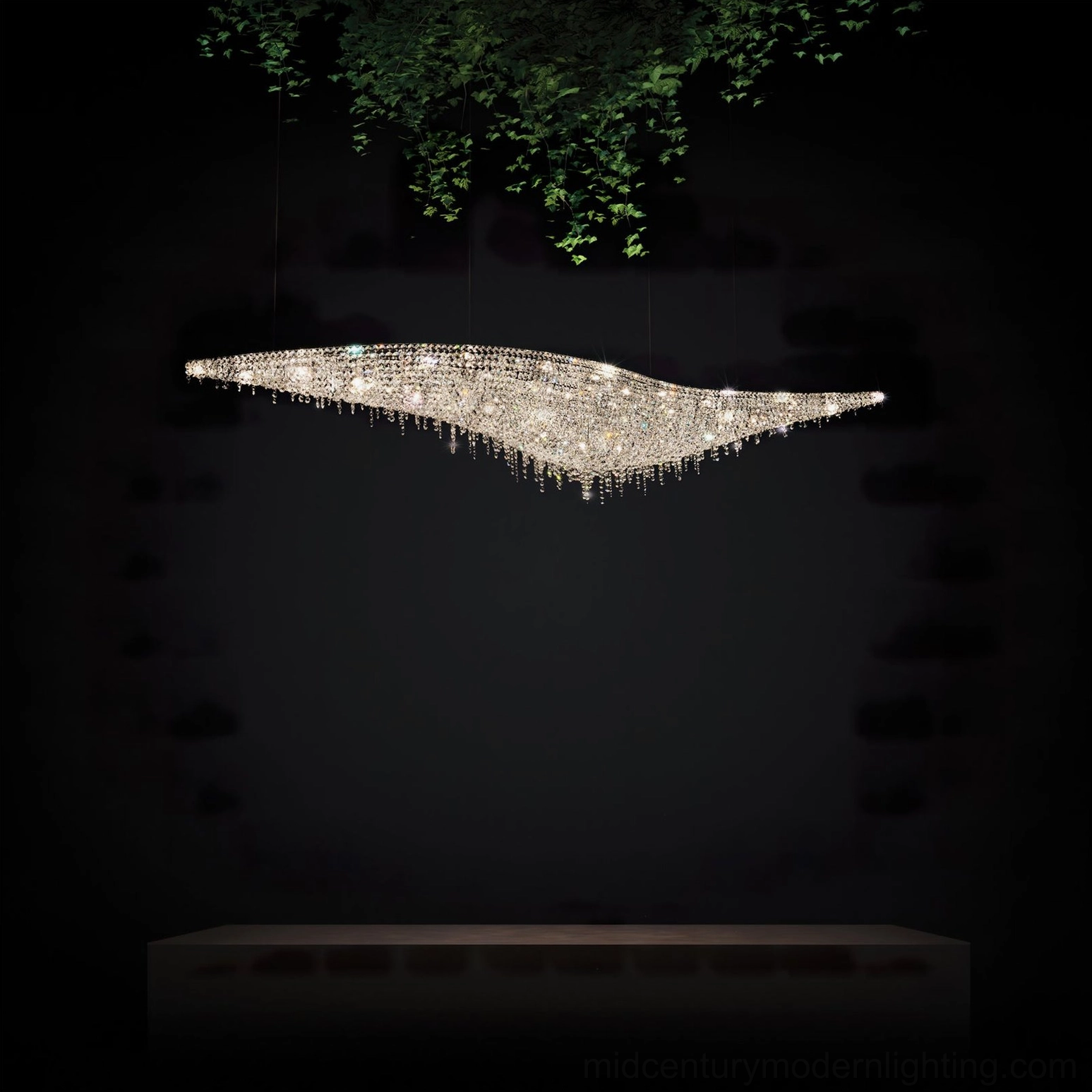 Modern leaves crystal chandelier installed over long console table in contemporary interior with hanging greenery