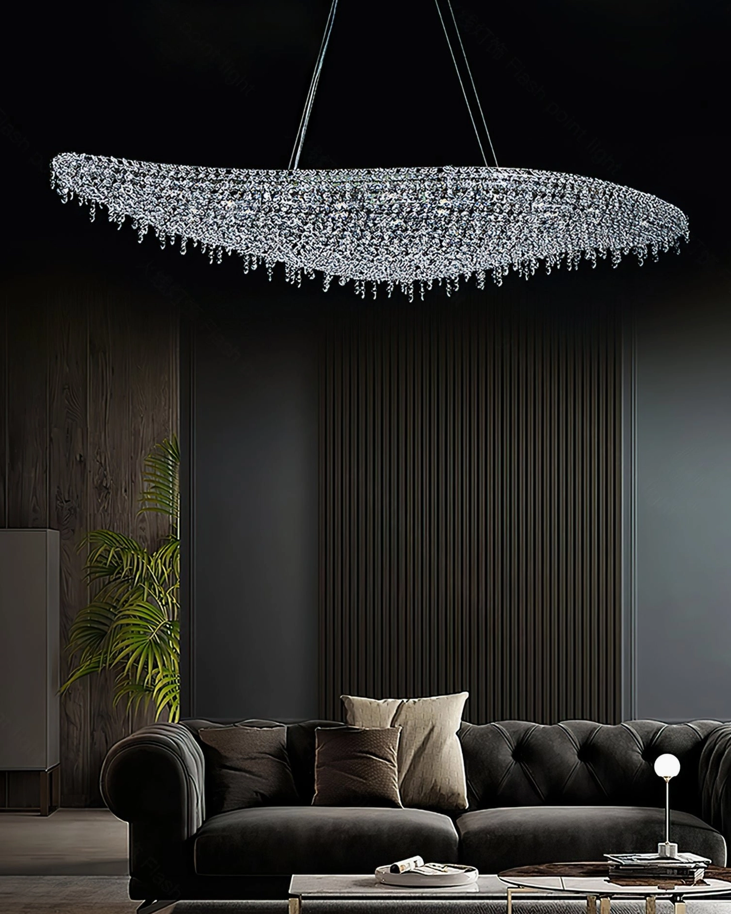 Overhead side view of leaves crystal chandelier installed in luxury dark living room above tufted sofa