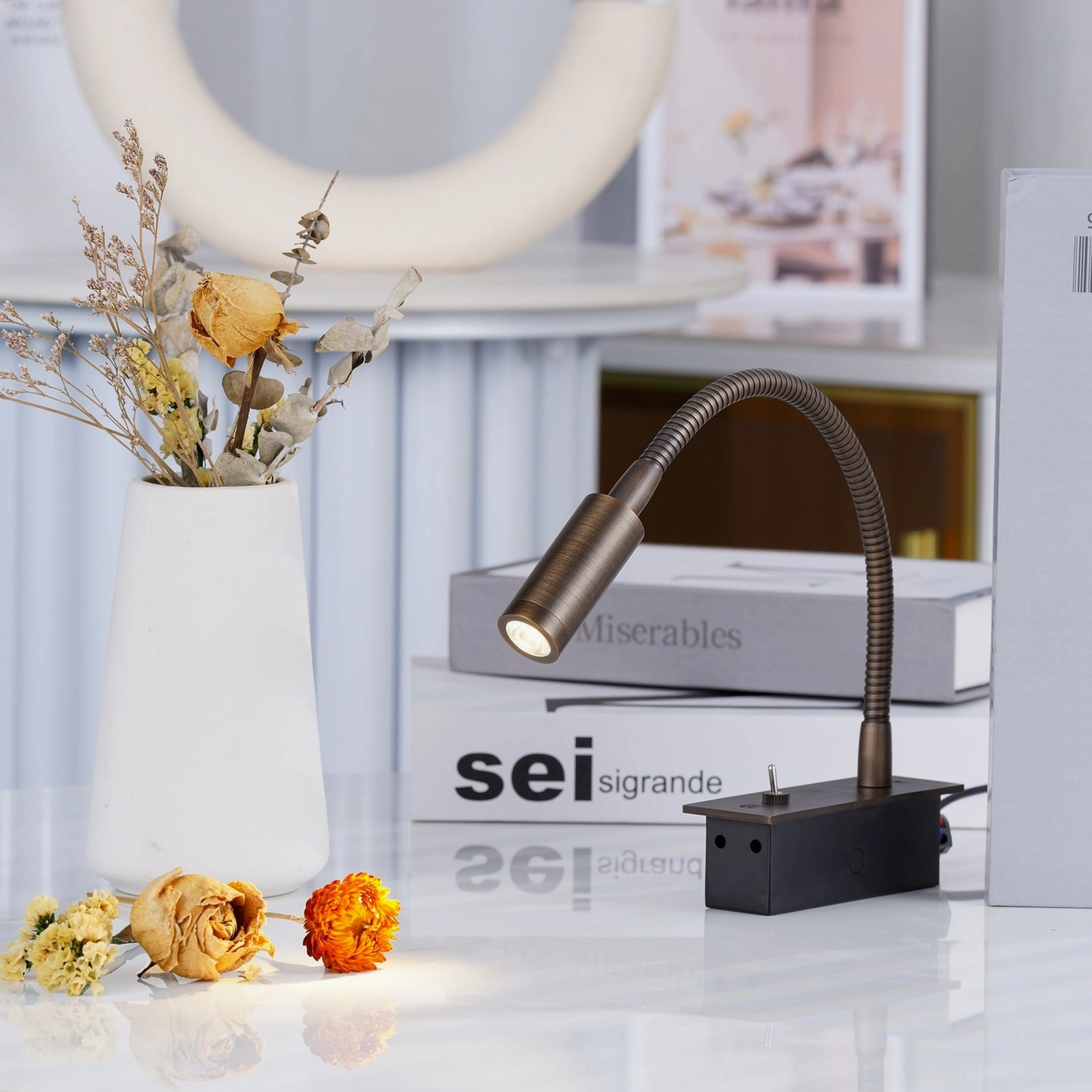 Bronze metal gooseneck accent light in three-quarter front view, minimalist display styling