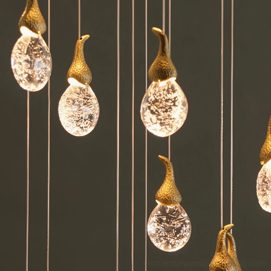 Close-up macro view of Leo Bubble Chandelier seeded clear glass orbs with gold textured metal tops