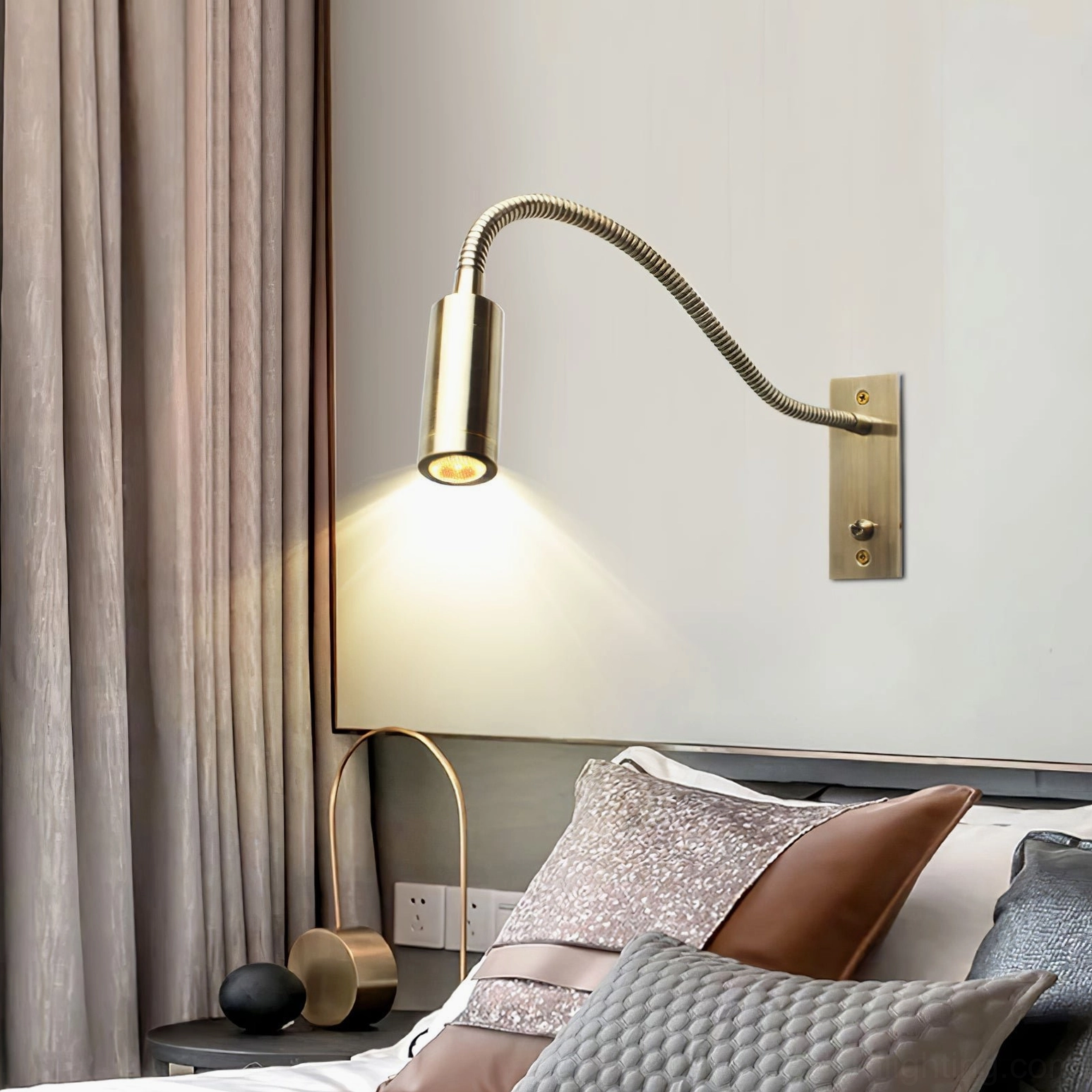 Brass gooseneck wall sconce illuminating bedside reading, low perspective cozy bedroom ambiance