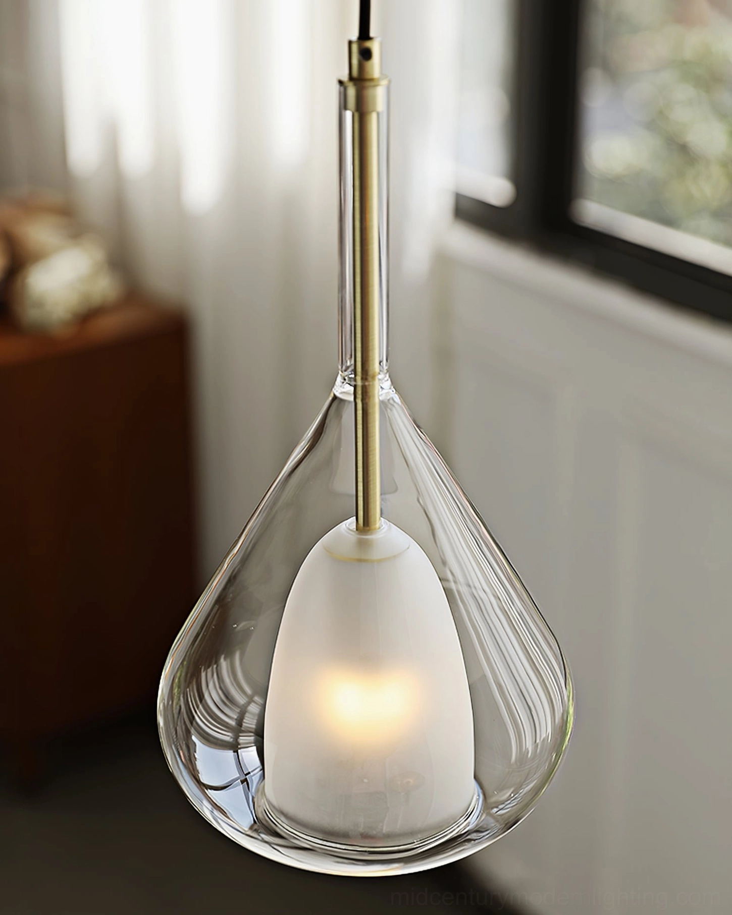 Lila teardrop pendant light in clear glass with gold metal frame and visible G9 bulb base