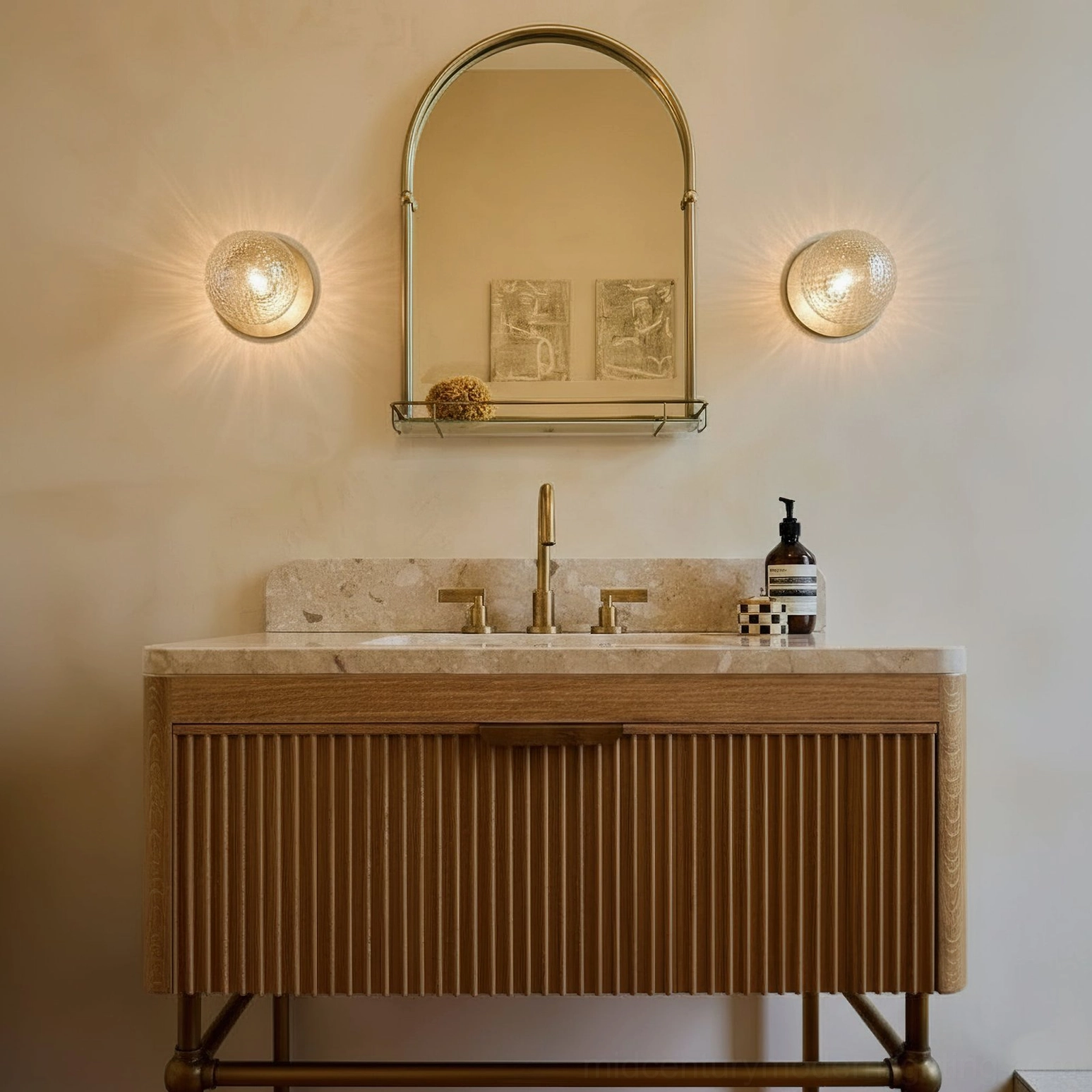 Pair of Lila brass wall sconces installed above bathroom vanity mirror in minimalist modern setting