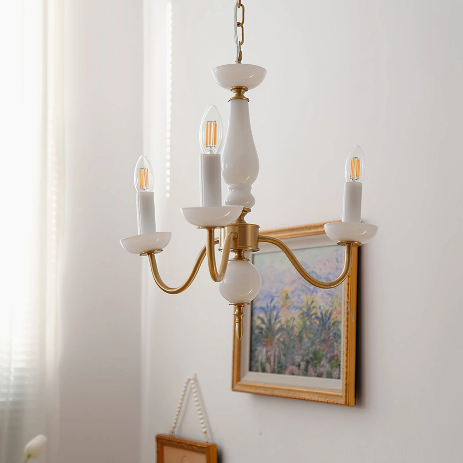 6-arm brass and white ceramic candle chandelier displayed in elegant retro interior setting with framed artwork