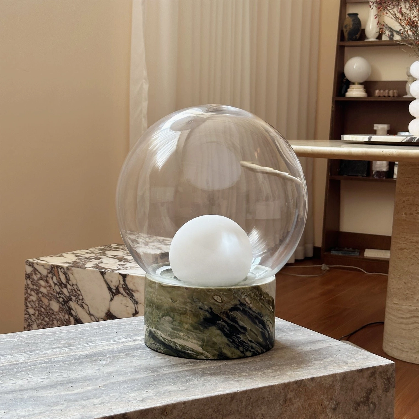 Lilly globe table lamp with frosted bulb and dark green marble base in modern stone furniture setting