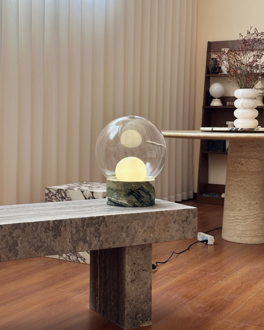 Lilly globe lamp glowing on stone bench in modern minimalist home with interior design styling