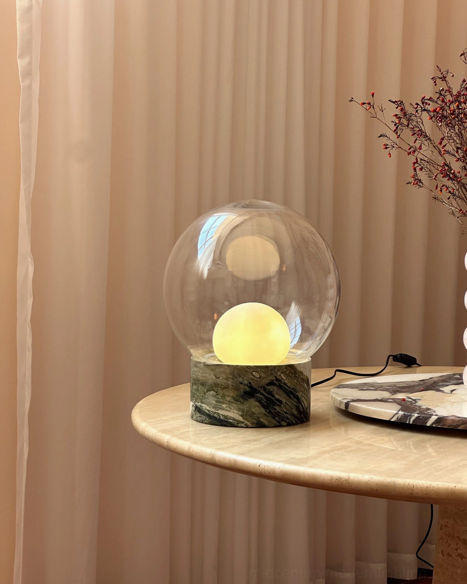 Lilly green marble lamp glowing with warm yellow light on marble table in modern home