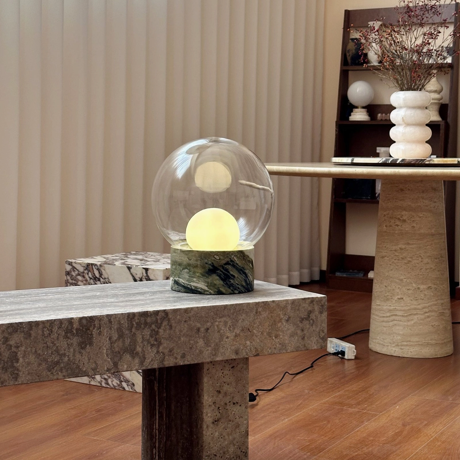 Lilly marble globe lamp with warm illumination in full modern home studio with wooden floors