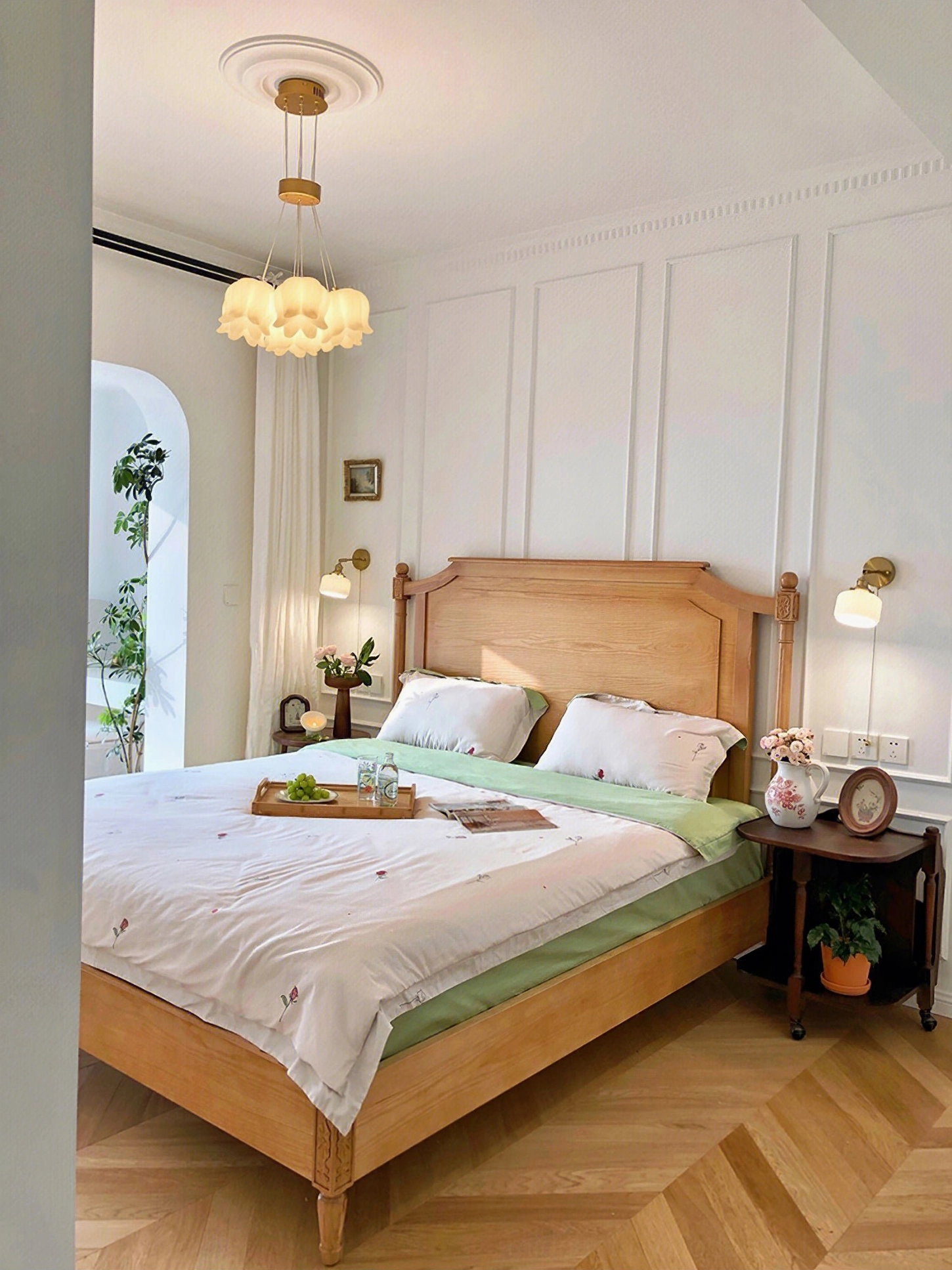 Botanical pendant chandelier suspended in French wooden bedroom creating warm ambient light and sculptural focal point