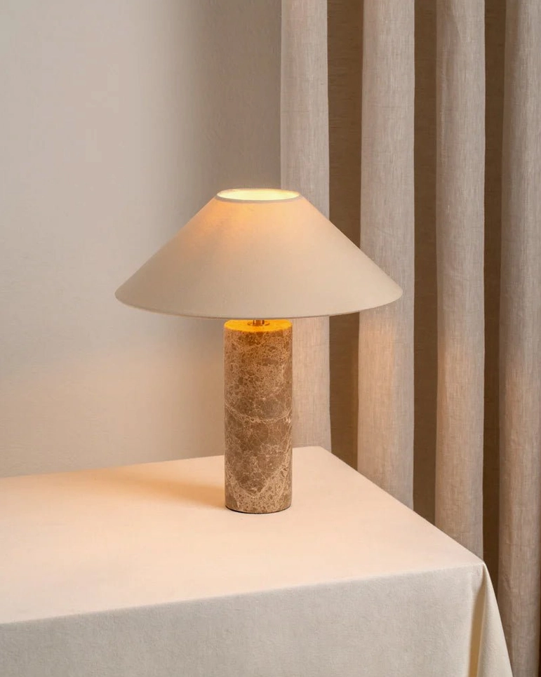 Limoges marble table lamp illuminated three-quarter view warm glow indoor scene with curtain backdrop