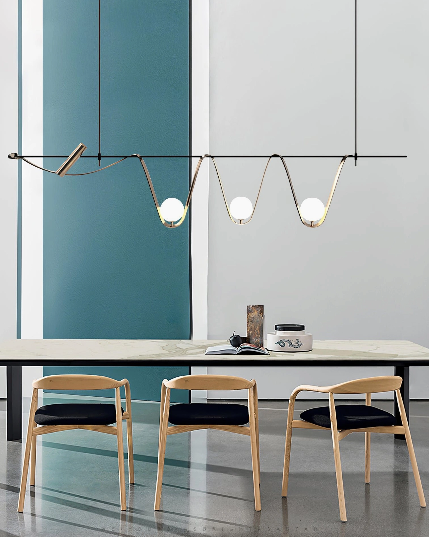 Linear chandelier close-up detail showing curved gold metal arms and frosted glass bulbs - architectural pendant design