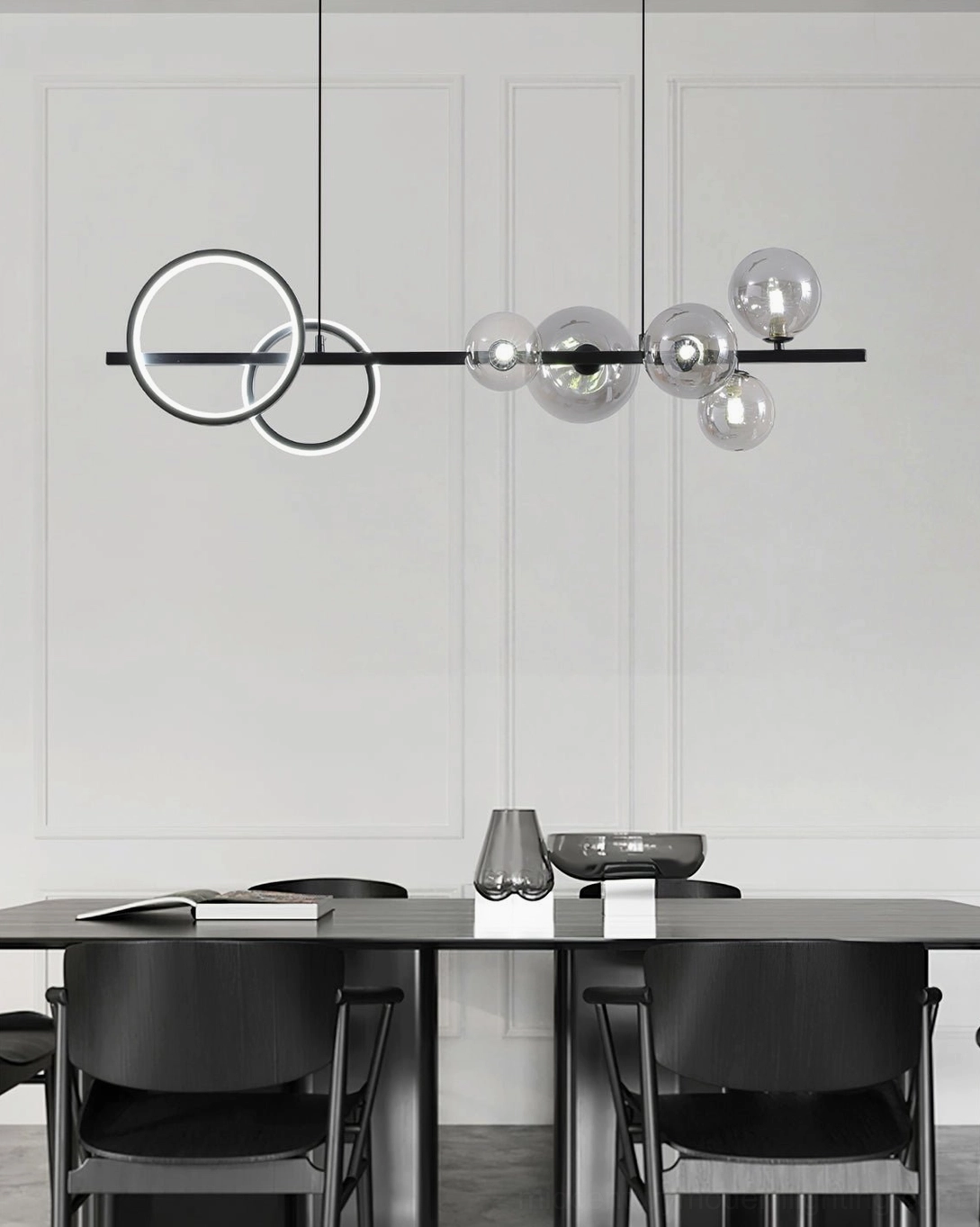 Linear glass bubble chandelier with black metal rod and dual circular light rings in modern dining room with panel walls