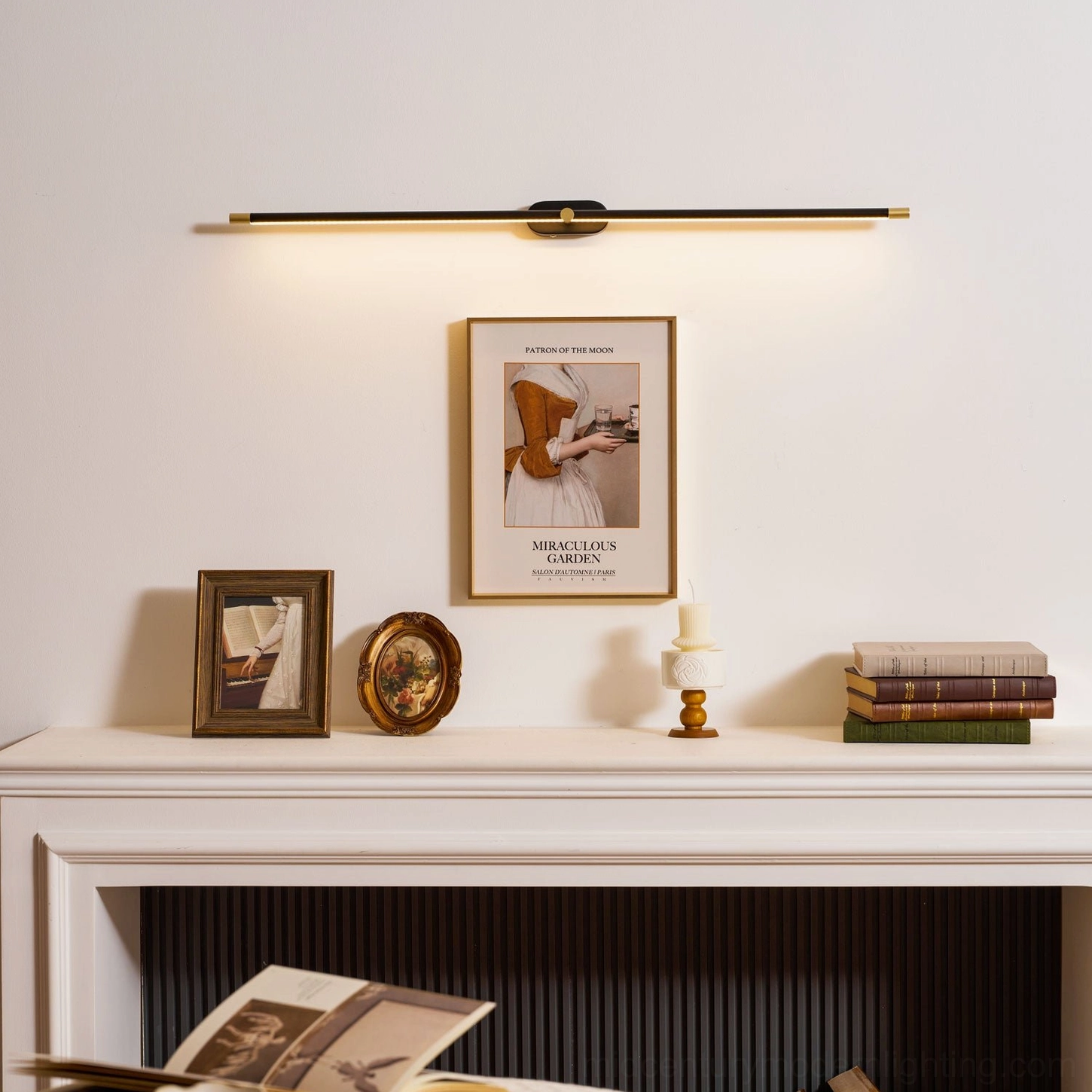 Modern linear wall light installed above fireplace mantel with framed art and vintage tabletop decor