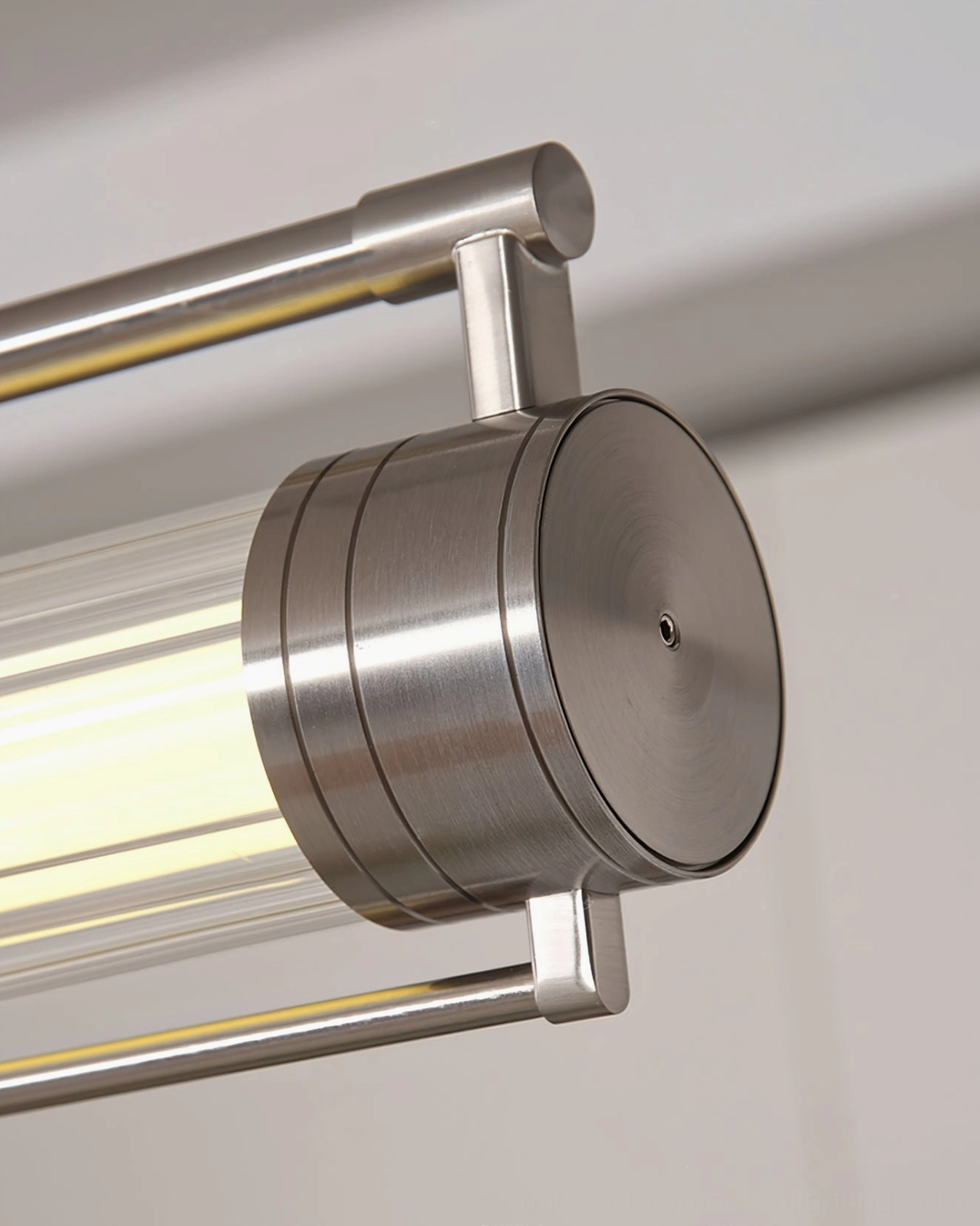 Detail of Lirna linear LED chandelier brushed nickel circular end cap on white background