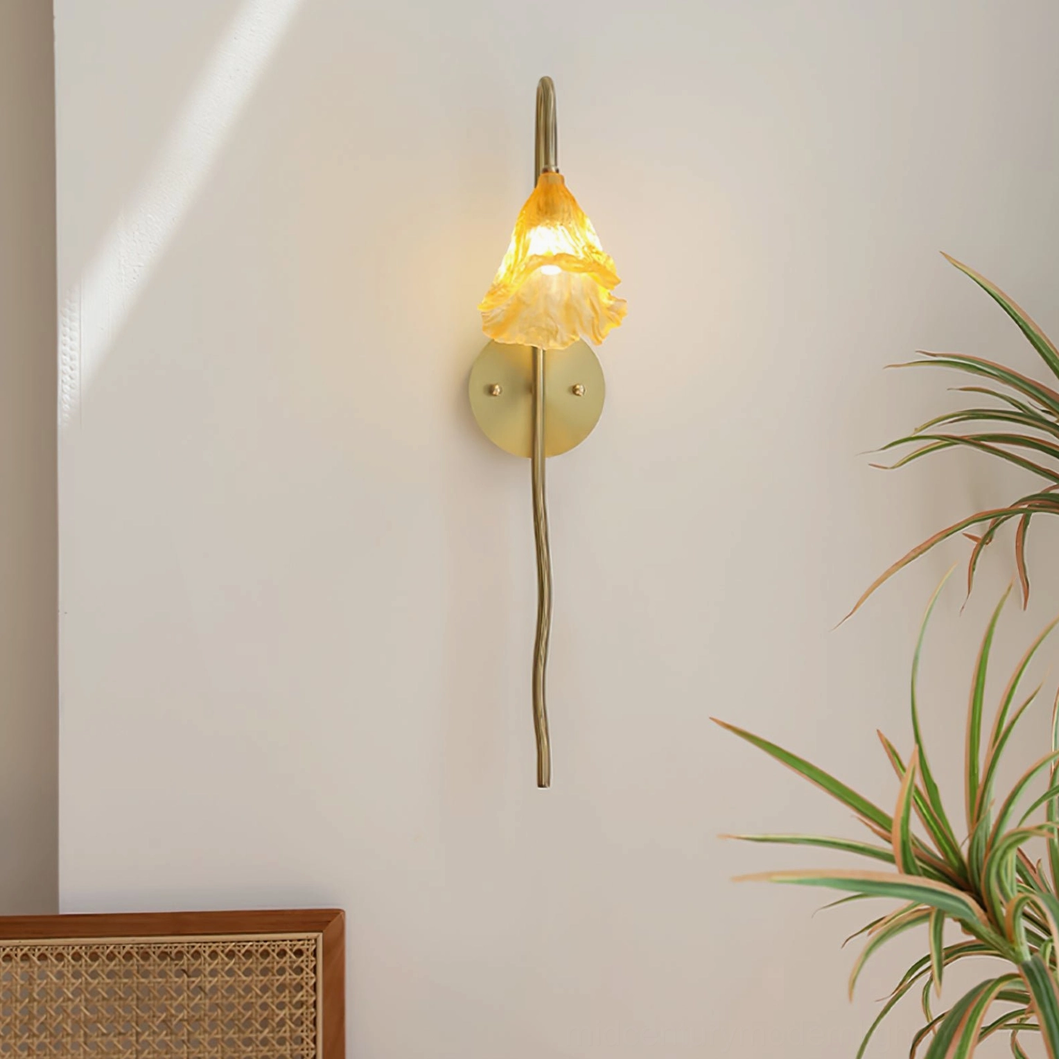 Illuminated Lotus Amber Wall Sconce with warm glowing amber shade creating ambient lighting, bohemian minimalist style with brass hardware