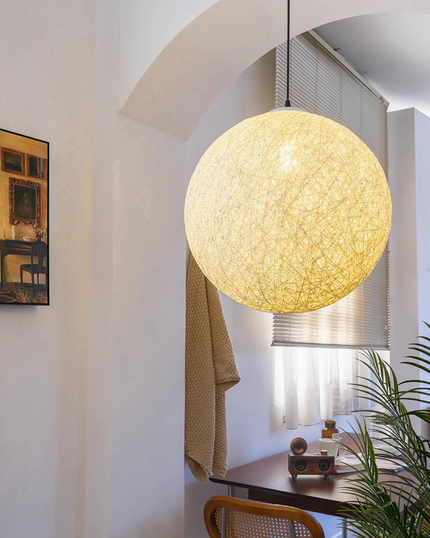 Lit rattan globe pendant light sunlit home workspace warm bohemian natural aesthetic