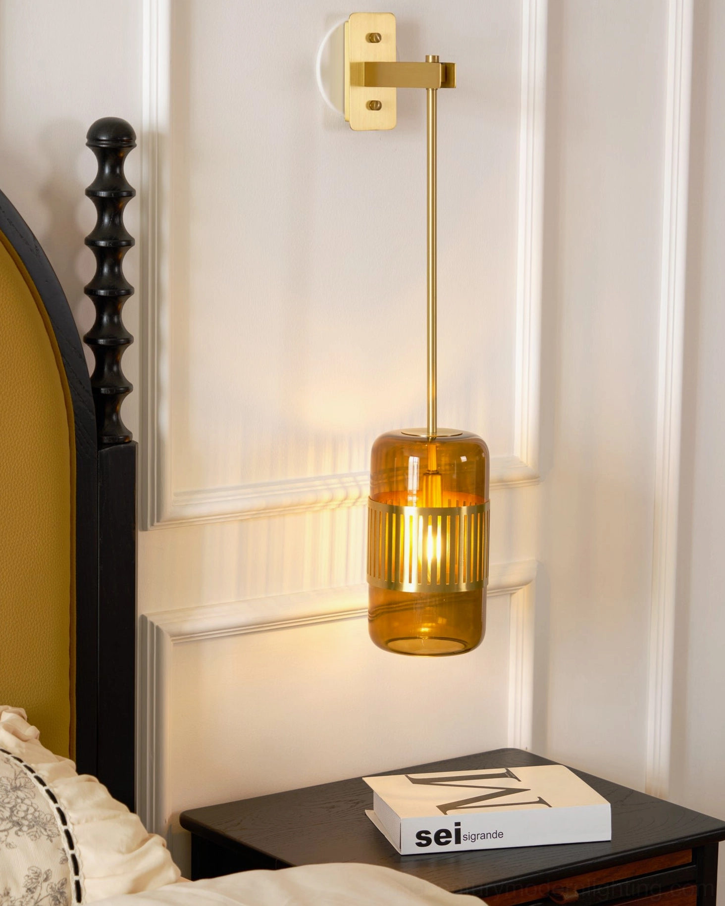 Lizak brass wall lamp installed as bedside sconce in neoclassical bedroom with arched headboard and warm lighting ambiance