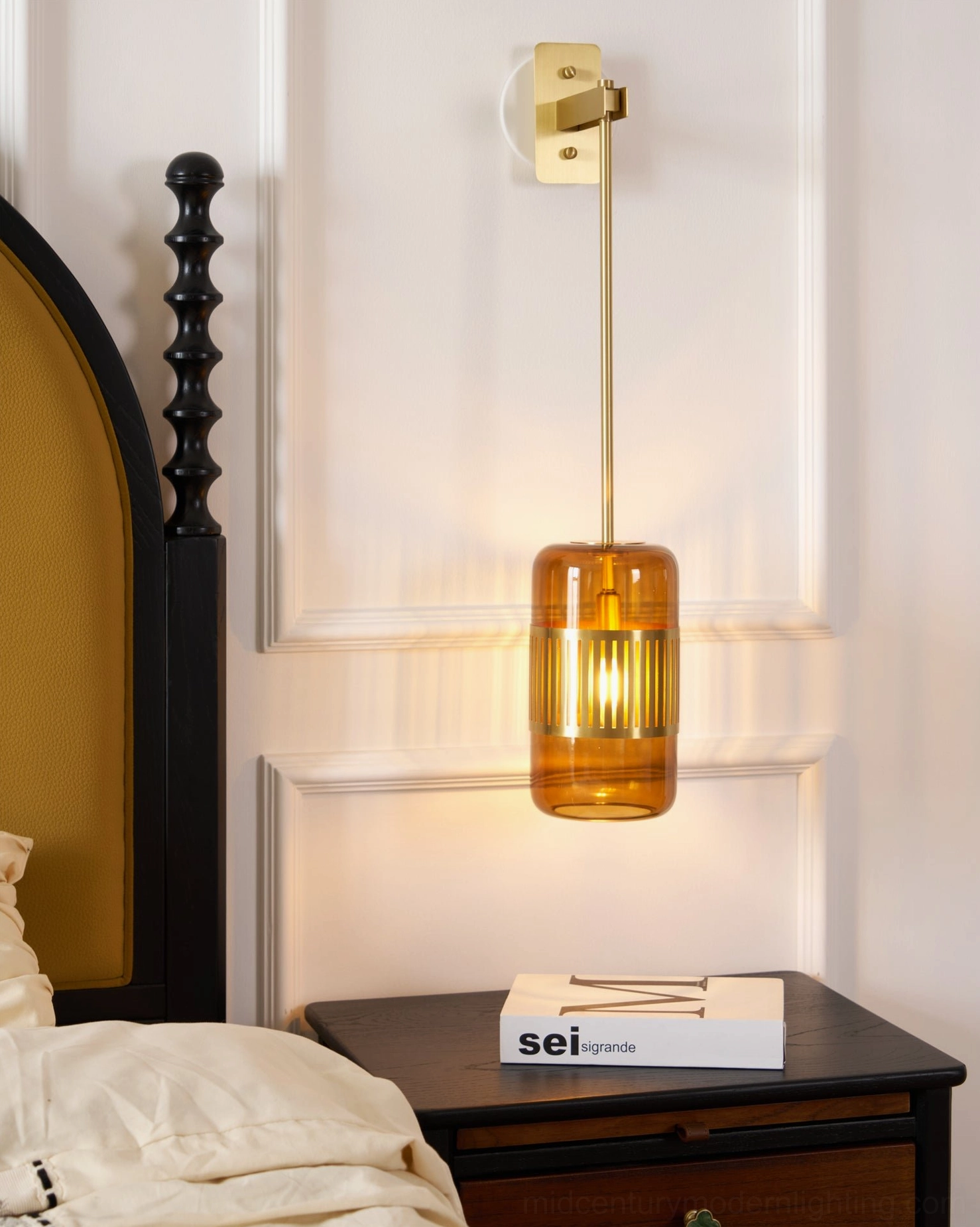 Lizak brass wall sconce with long hanging rod mounted in bedroom with arched headboard, elegant minimalist wall lighting