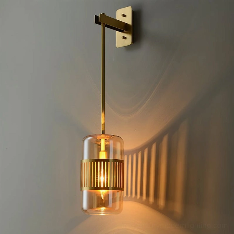Lizak green glass wall lamp mounted on grey wall showing decorative shadow pattern cast by brass slats, close-up detail view