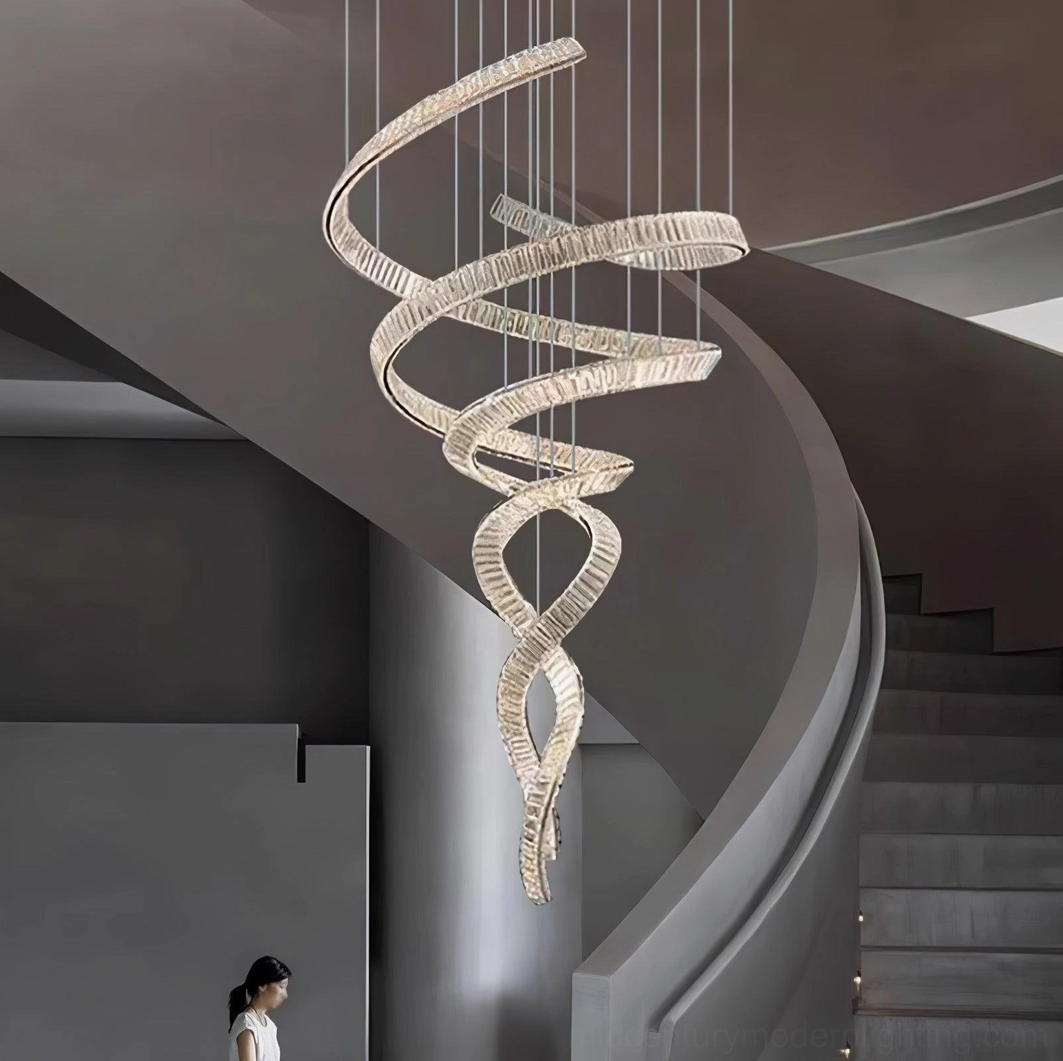 Long spiral crystal chandelier installation view, stainless steel frame with clear faceted crystals, mid-century modern aesthetic