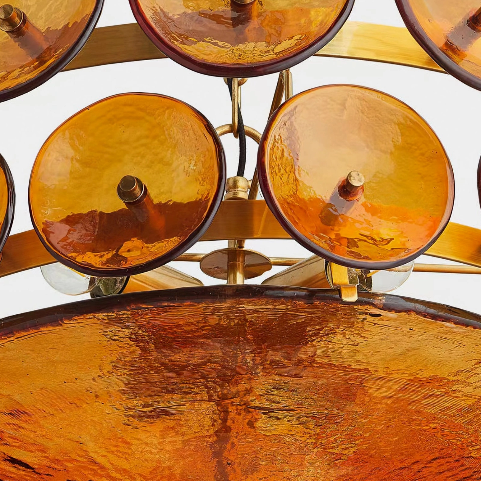 Lorenzo chandelier layered glass discs and polished brass metal frame architectural detail macro shot