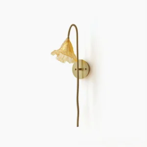 Lotus Amber Glass Wall Sconce with brushed brass mounting and curved arm on white wall, front view showing ruffled amber shade