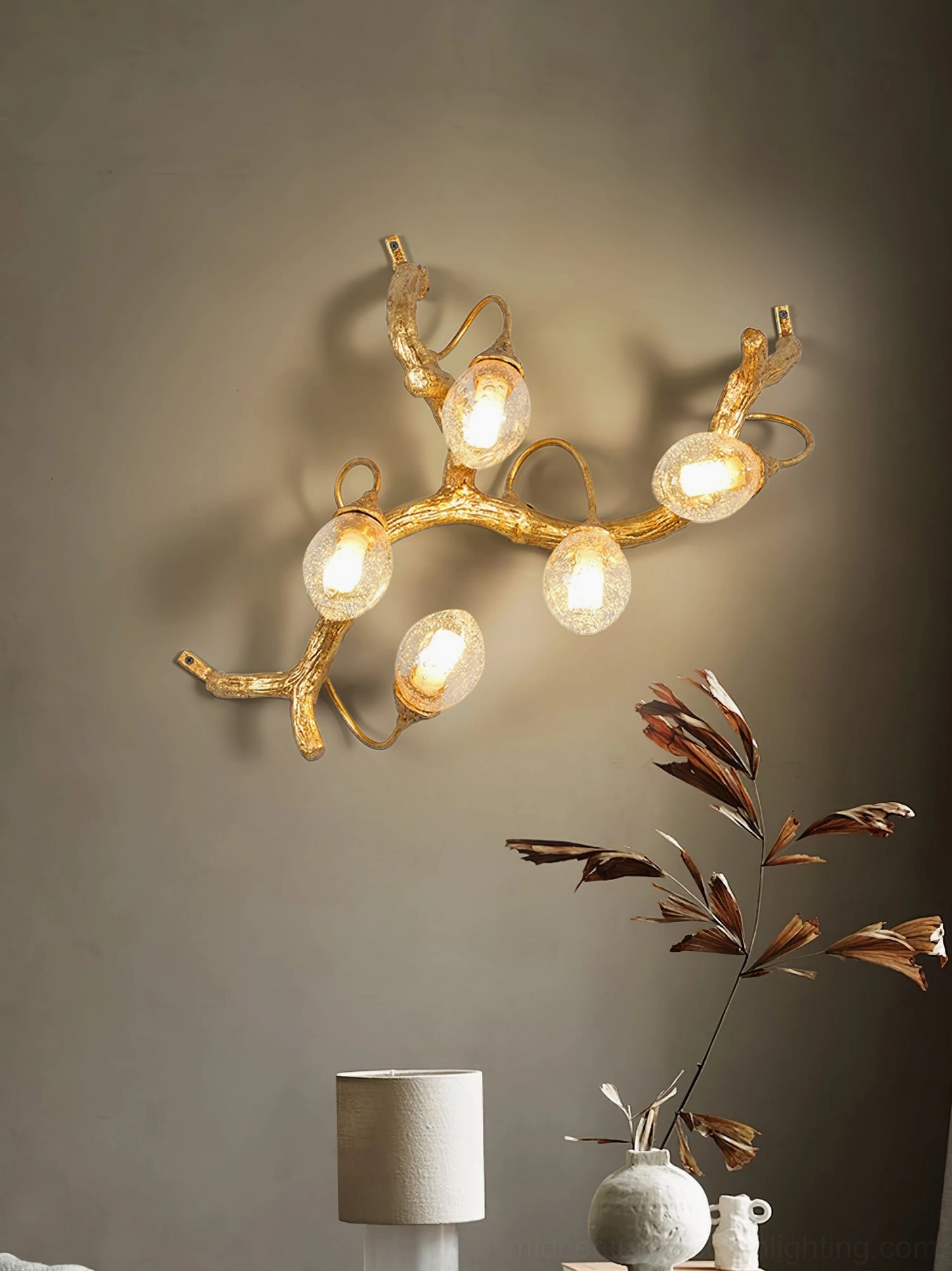 Lotus brass wall lamp mounted above console table with natural wood and decorative accessories