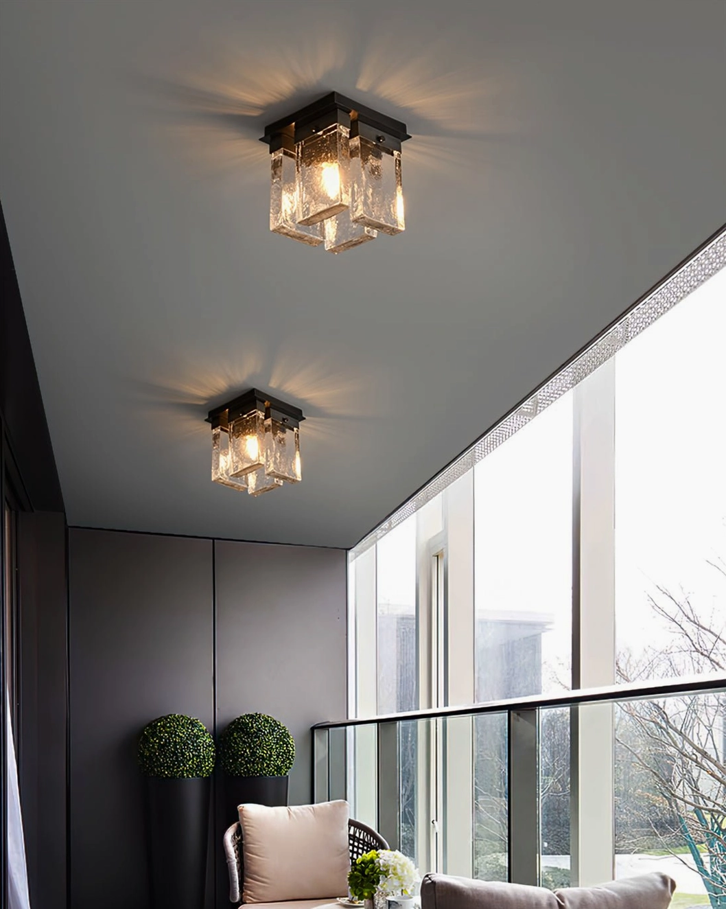 Multiple black ceiling flush mount lights on modern balcony lounge area with bright outdoor space