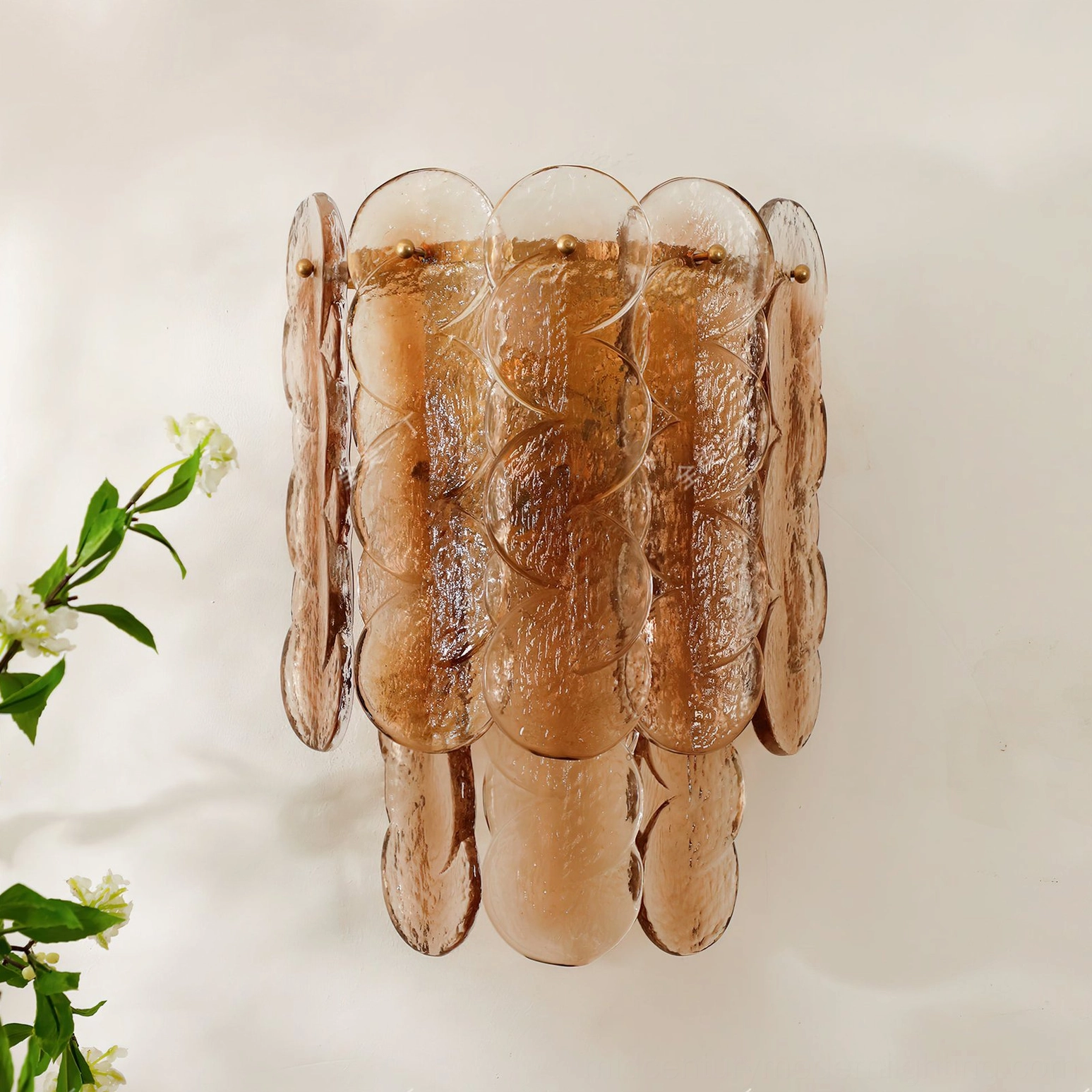 Low-angle view of glass wall sconce showing detailed rippled surface in sunlight