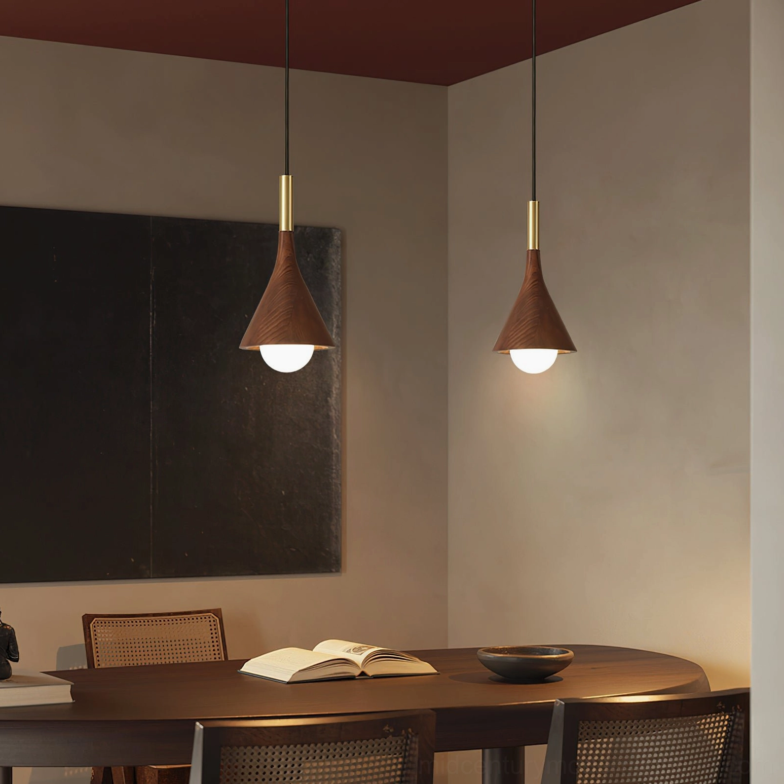 Pair of Lucian walnut and brass pendant lights above minimalist dining room table