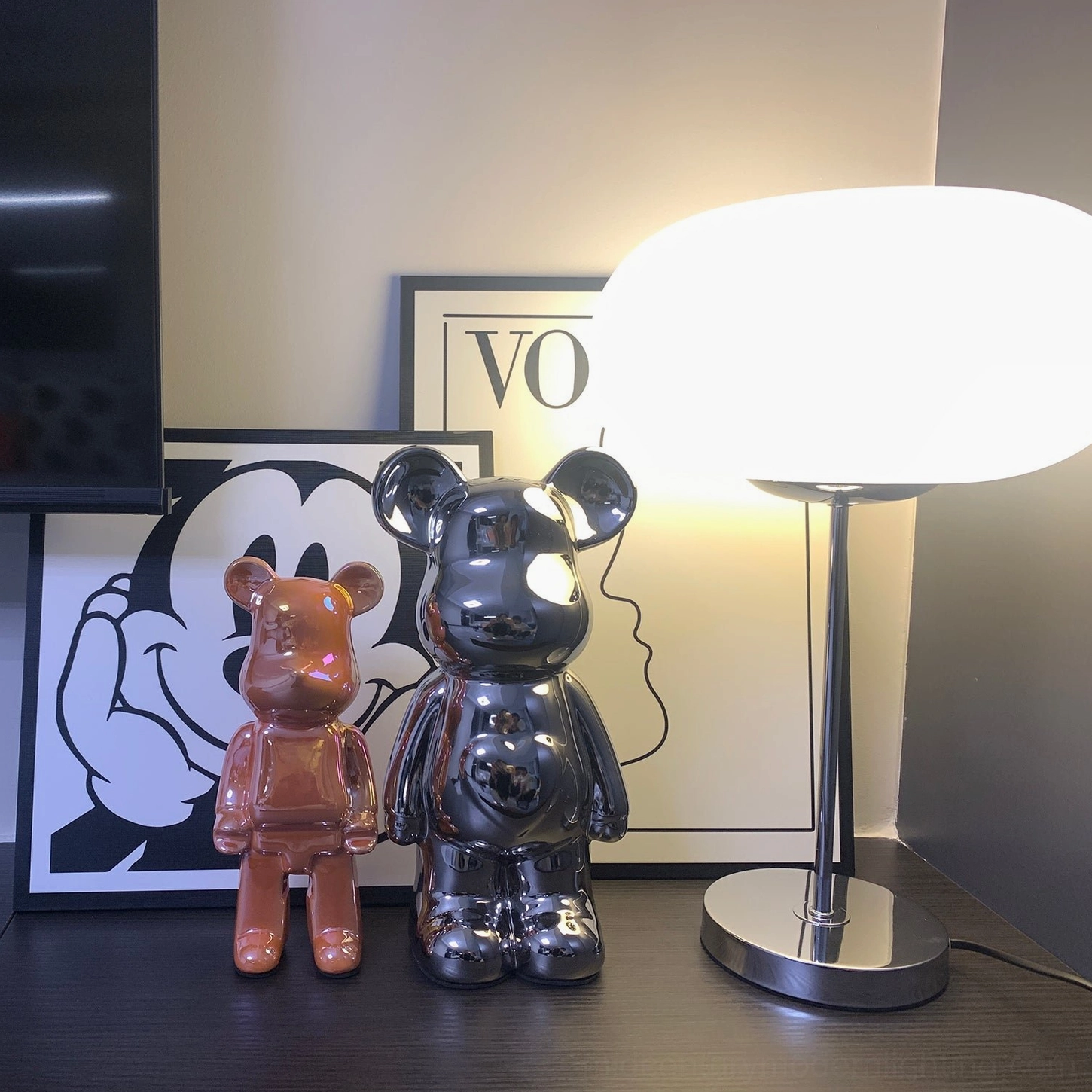 Frosted glass table lamp on shelf styling with decorative accessories and figurines