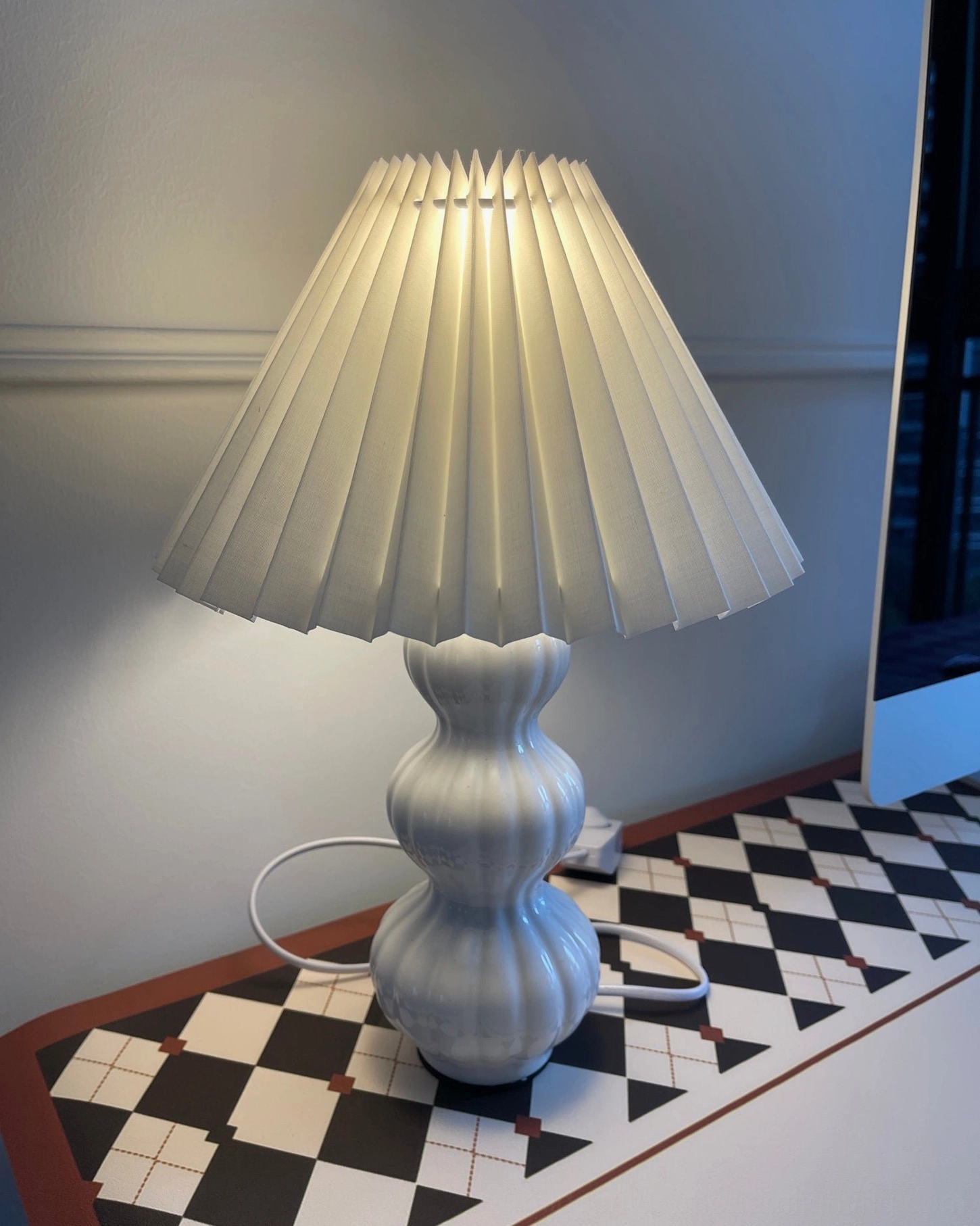 Luna pleated table lamp in home office environment, focused yet gentle illumination for desk work and study