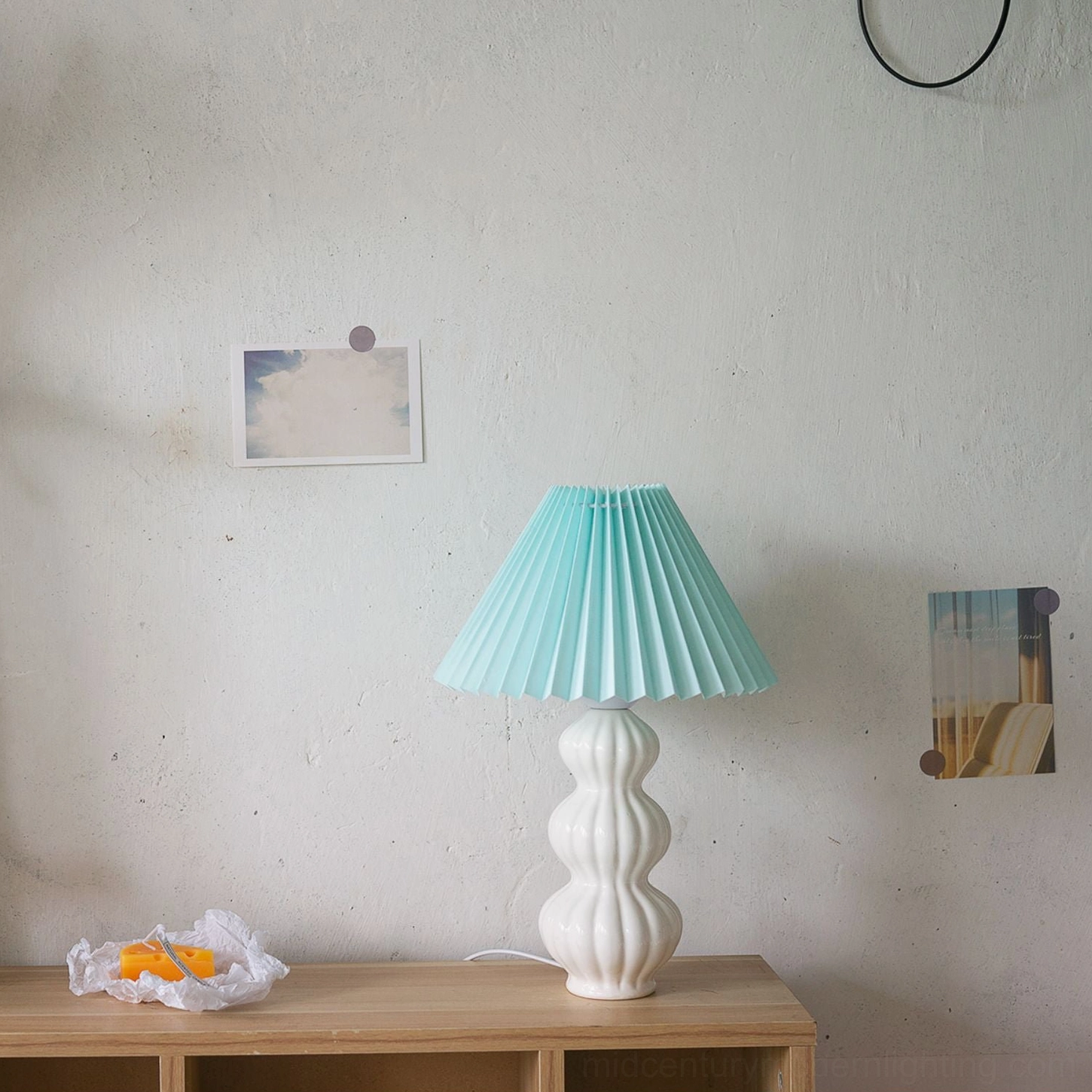Luna pleated table lamp with mint green shade on wooden side table, smooth glossy white ceramic base, Nordic minimalist style