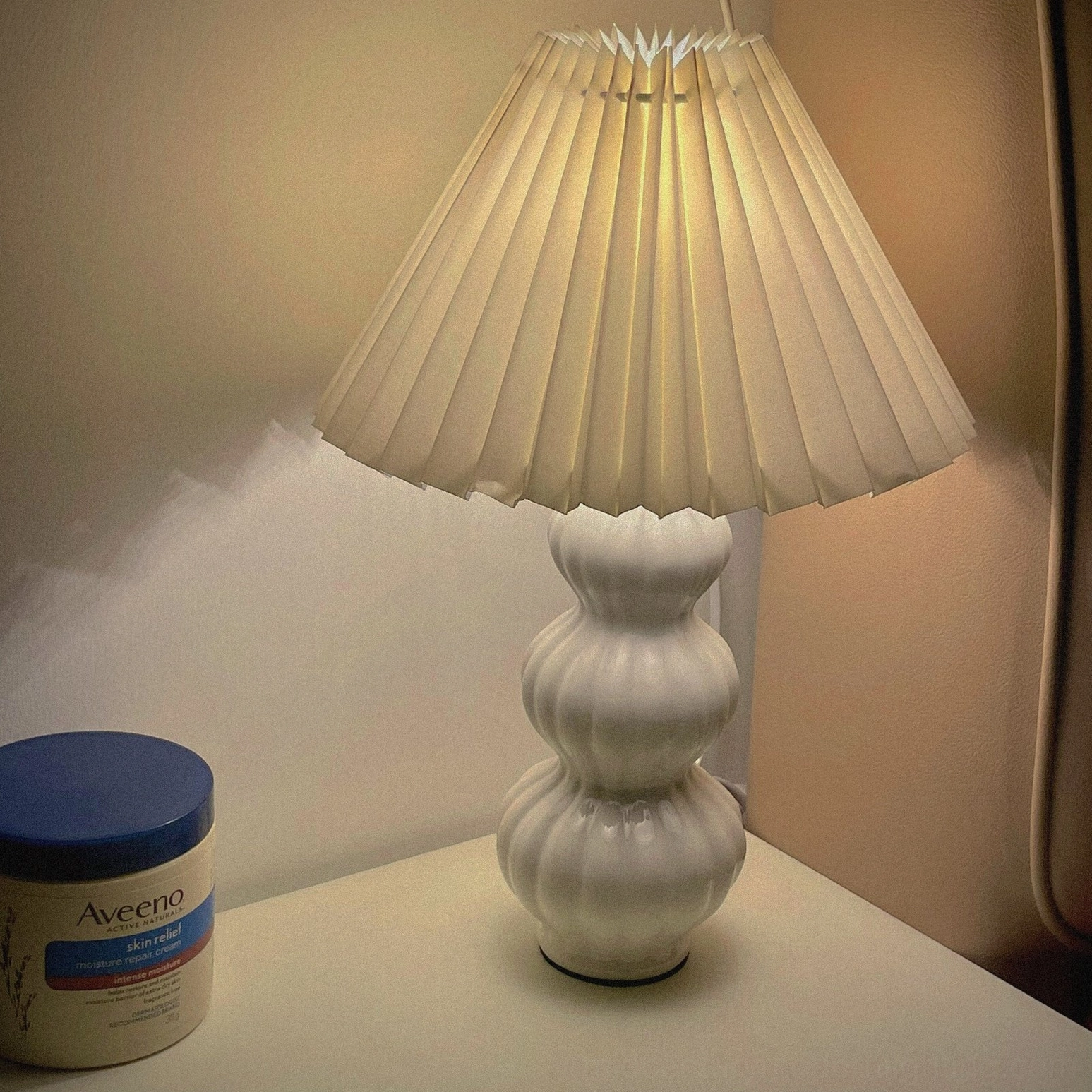 Luna pleated table lamp in minimalist Nordic interior, warm ceramic base with clean modern aesthetic