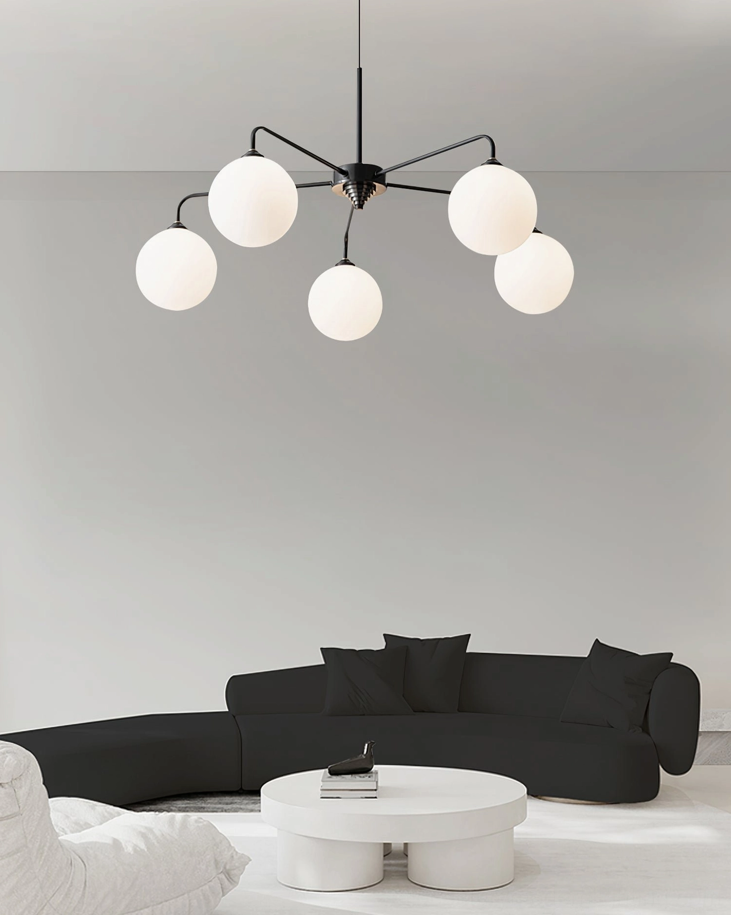 Full frontal view of Lune chandelier with five frosted glass spheres and sculptural brass framework