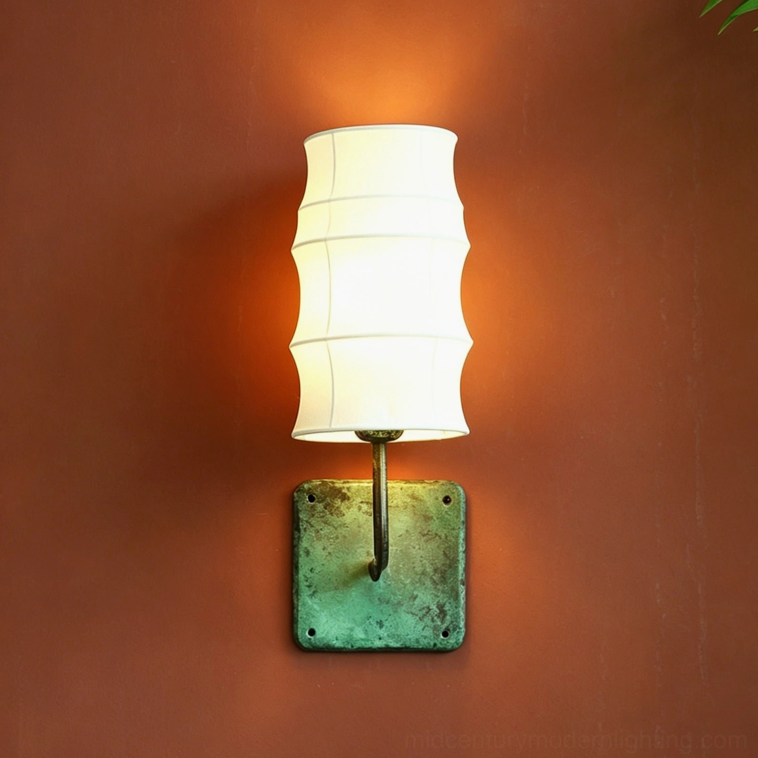 Close-up of Maeve Lantern Wall Sconce showing stacked tiered fabric shade and aged green metal base