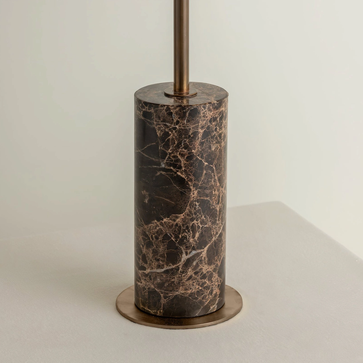 Close-up of marble lamp base - cylindrical marble with natural veining and bronze metal hardware