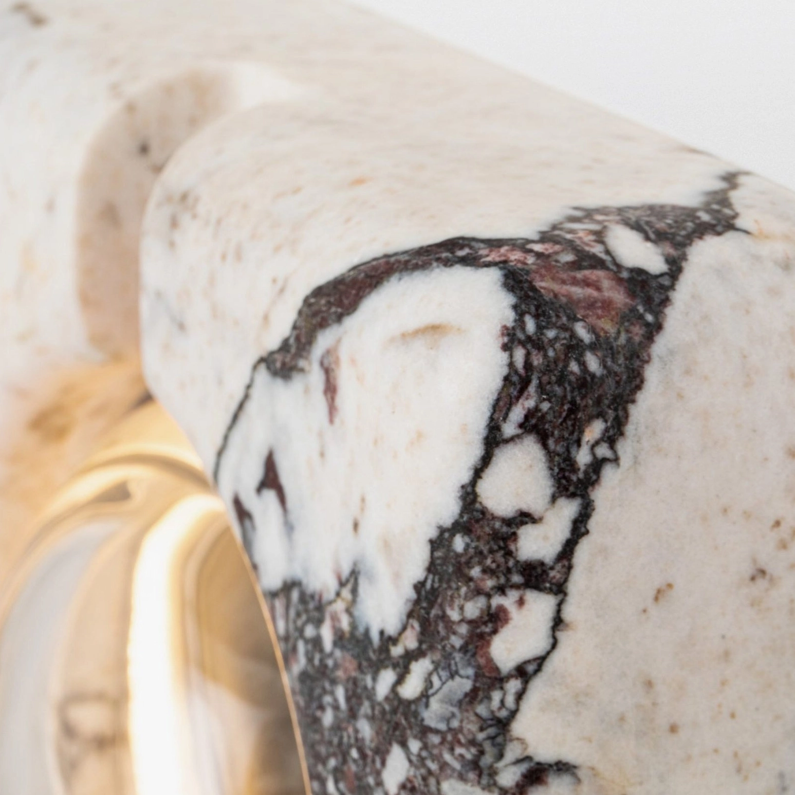 Detail shot of marble wall lamp corner showing natural stone texture and rough surface