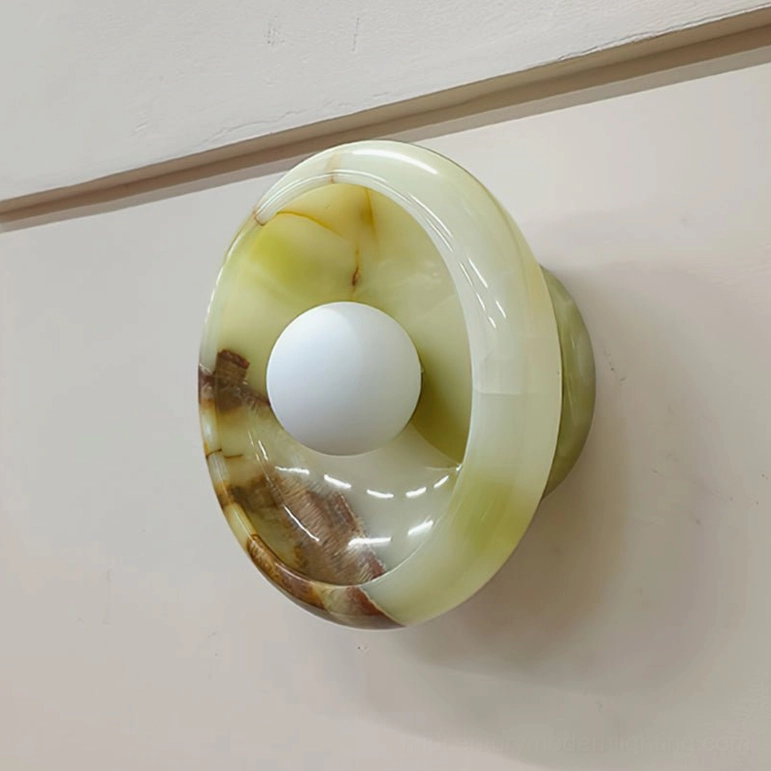 Marble wall lamp with green onyx stone, glossy translucent texture, oblique front view in indoor home setting