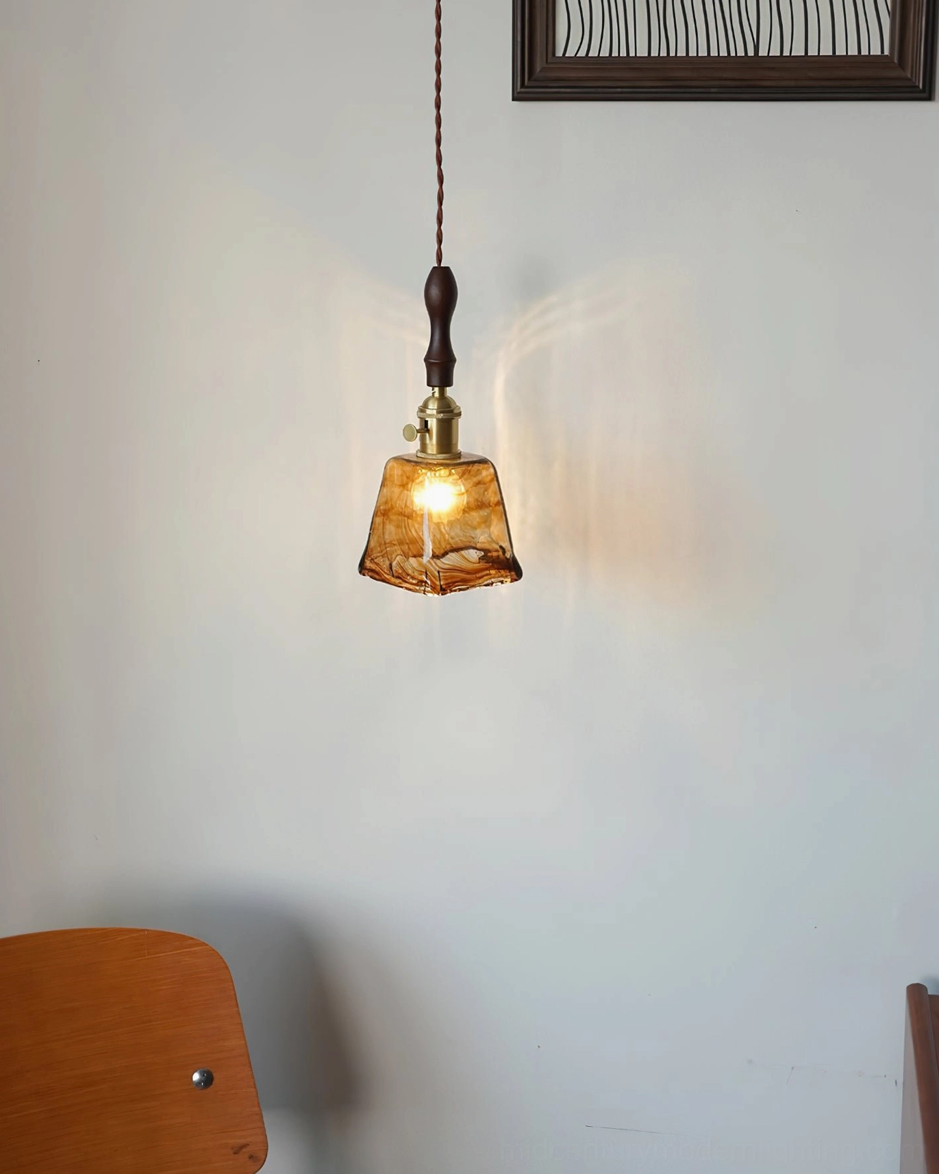 Marbled amber glass pendant lamp with brass accents in contemporary room lighting design