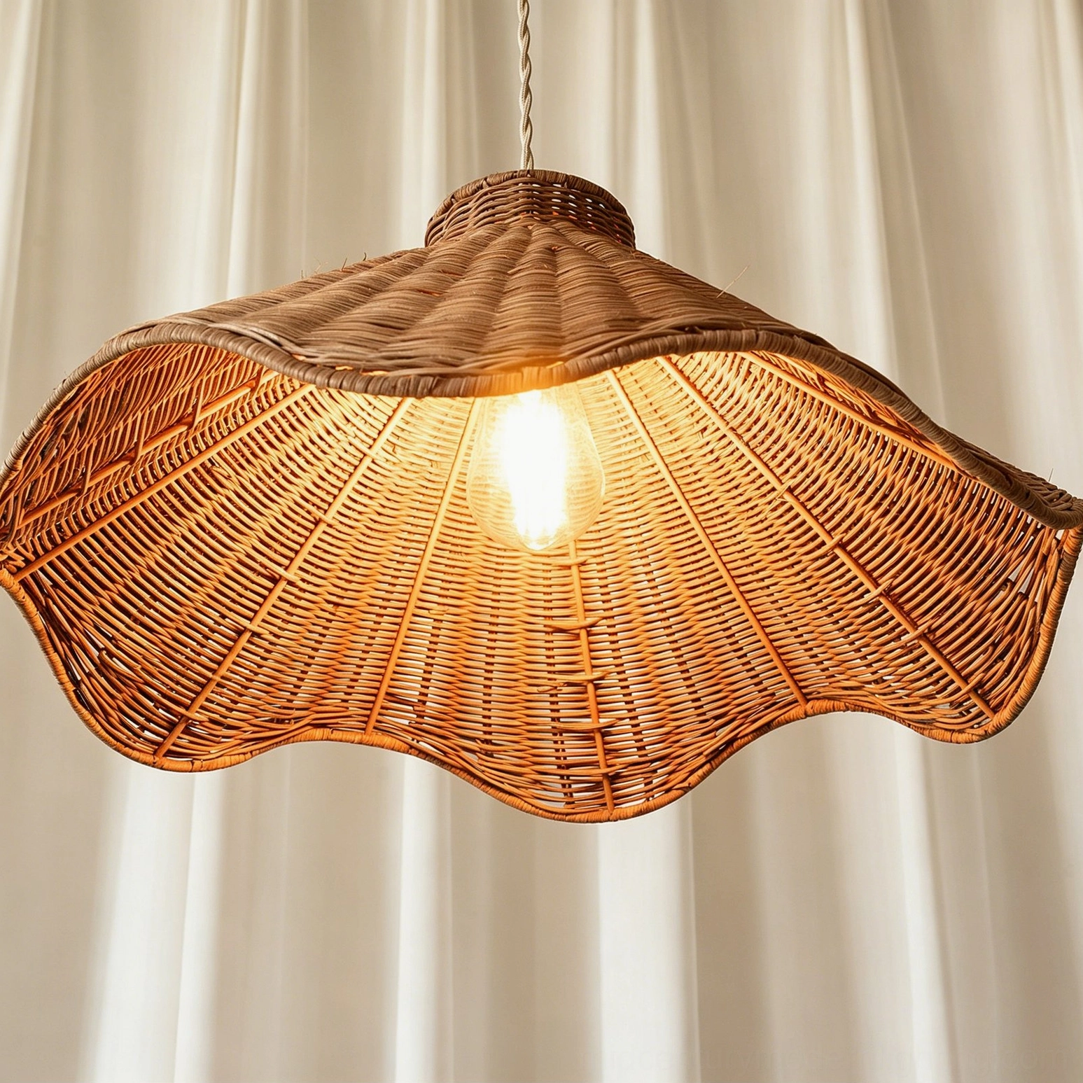 Maren sculptural rattan pendant light close-up front view highlighting woven rattan texture detail with exposed glowing bulb inside