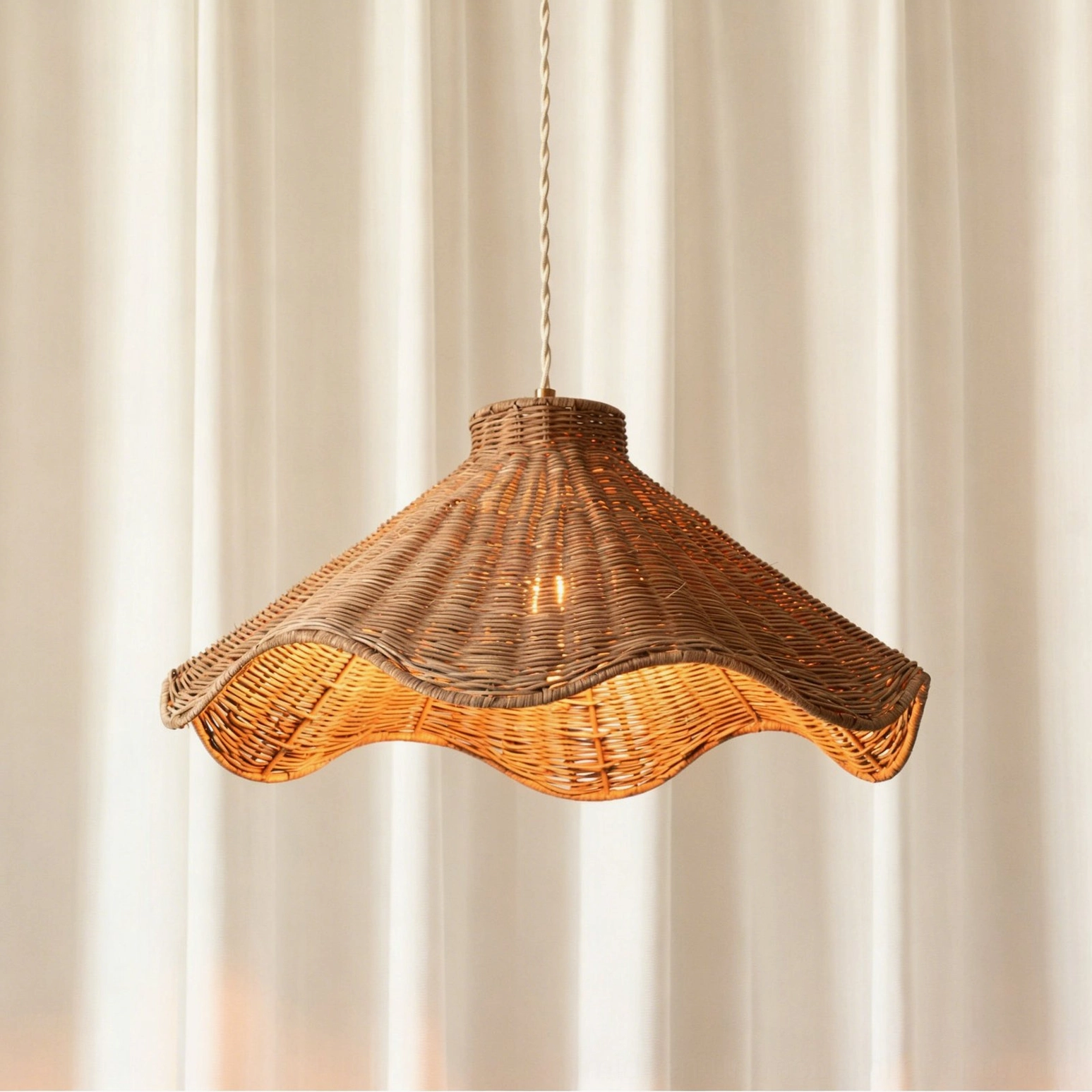 Maren sculptural rattan pendant light frontal view against sheer curtains showing warm brown woven rattan finish in minimalist studio setting