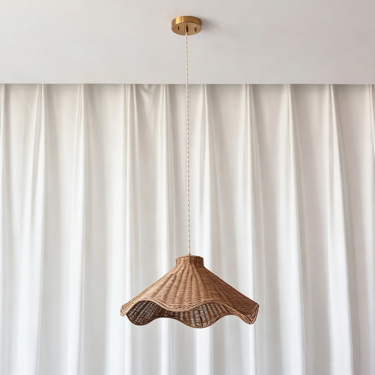 Maren sculptural rattan pendant light three-quarter view showing scalloped wave form and rattan texture in natural lighting
