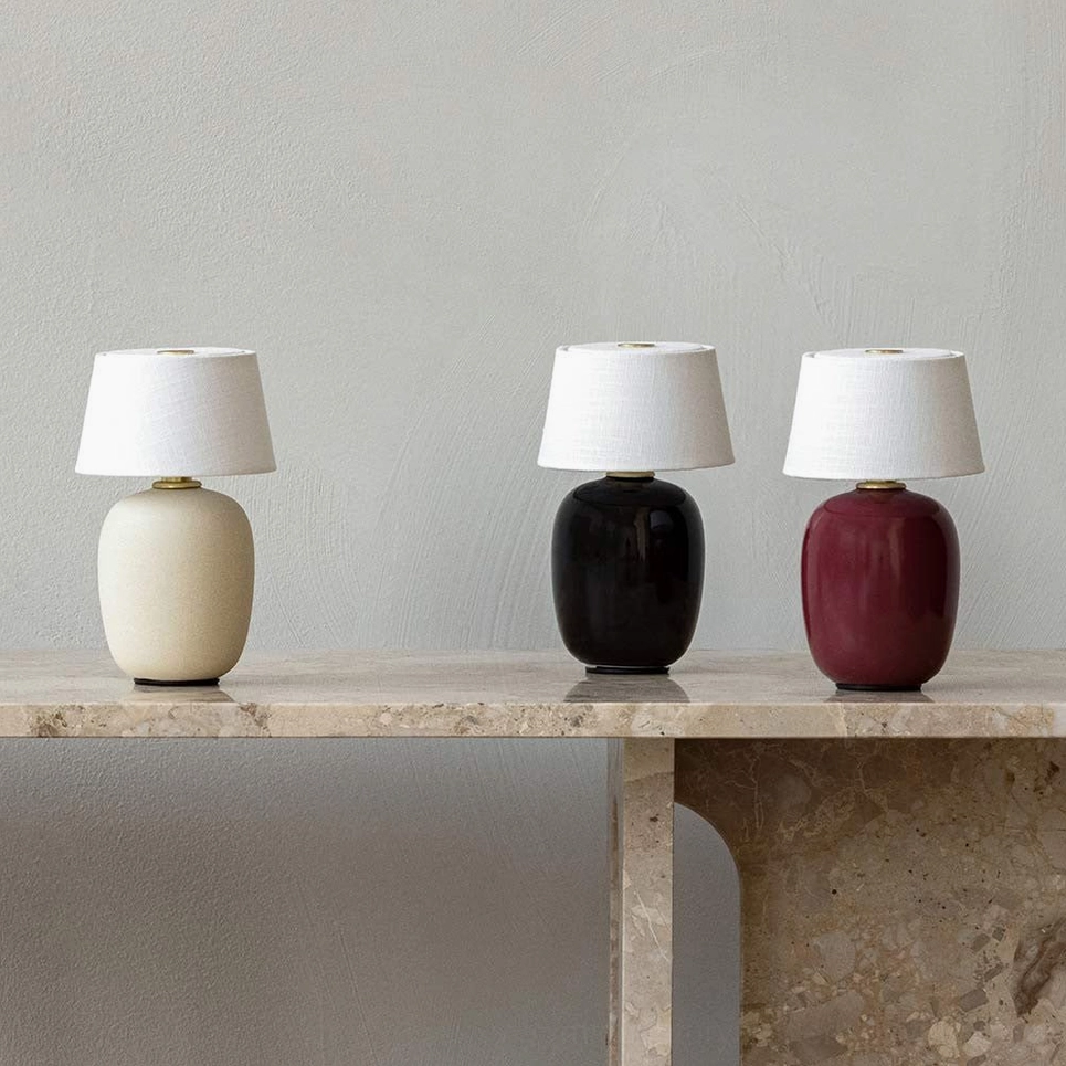 Three Marie table lamps in all color variants on marble console table showing sand color black and red finishes